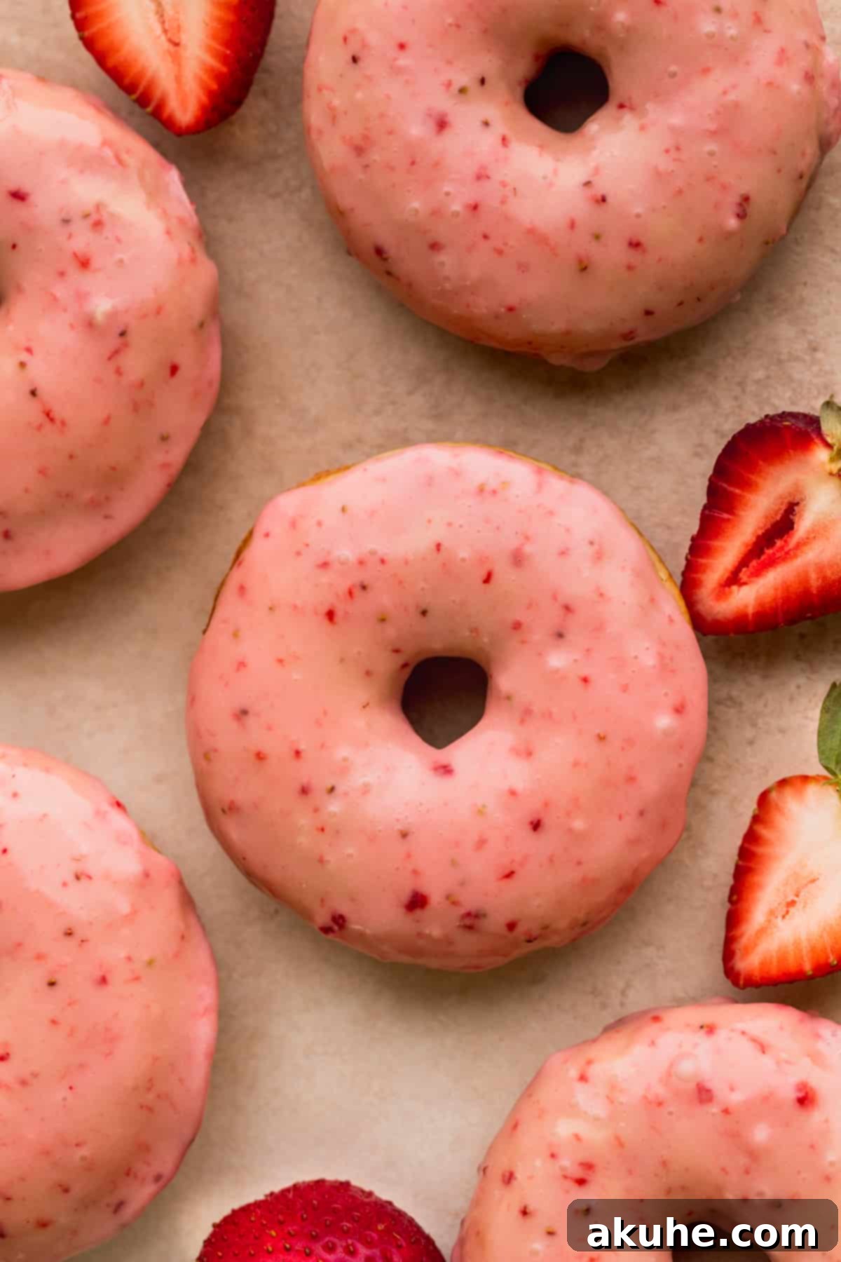 Glazed Strawberry Treats 2 Close up of strawberry glazed donuts with strawberries on the side.