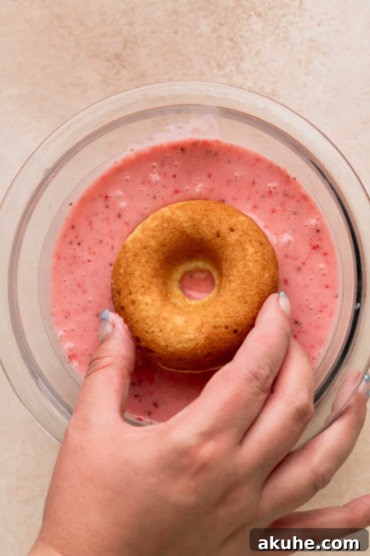 Glazed Strawberry Treats 9 Dipping donut into a glass bowl.
