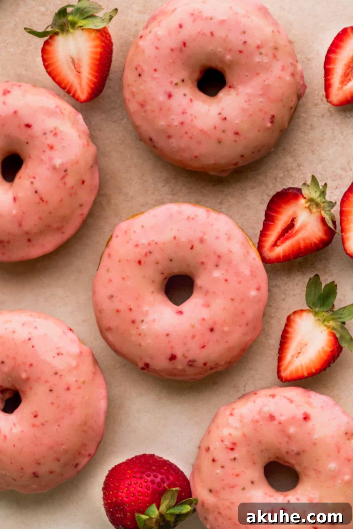 Glazed Strawberry Treats 10 Strawberry glazed donuts laid out.
