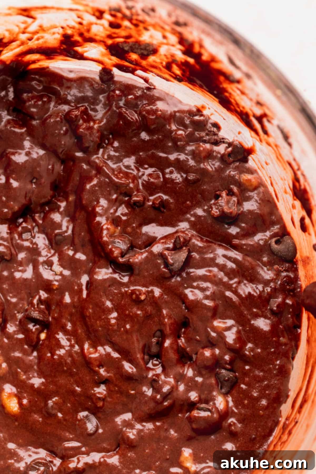 Decadent Double Chocolate Banana Bread 6 A close-up view of the rich, chocolatey banana bread batter in a glass bowl, studded with chocolate chips.