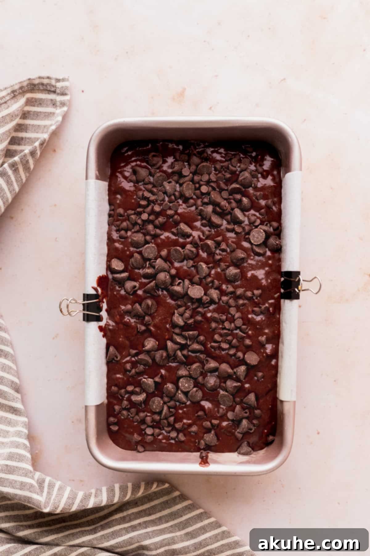 Decadent Double Chocolate Banana Bread 7 Unbaked double chocolate banana bread batter in a loaf pan, topped with an generous sprinkle of extra chocolate chips.