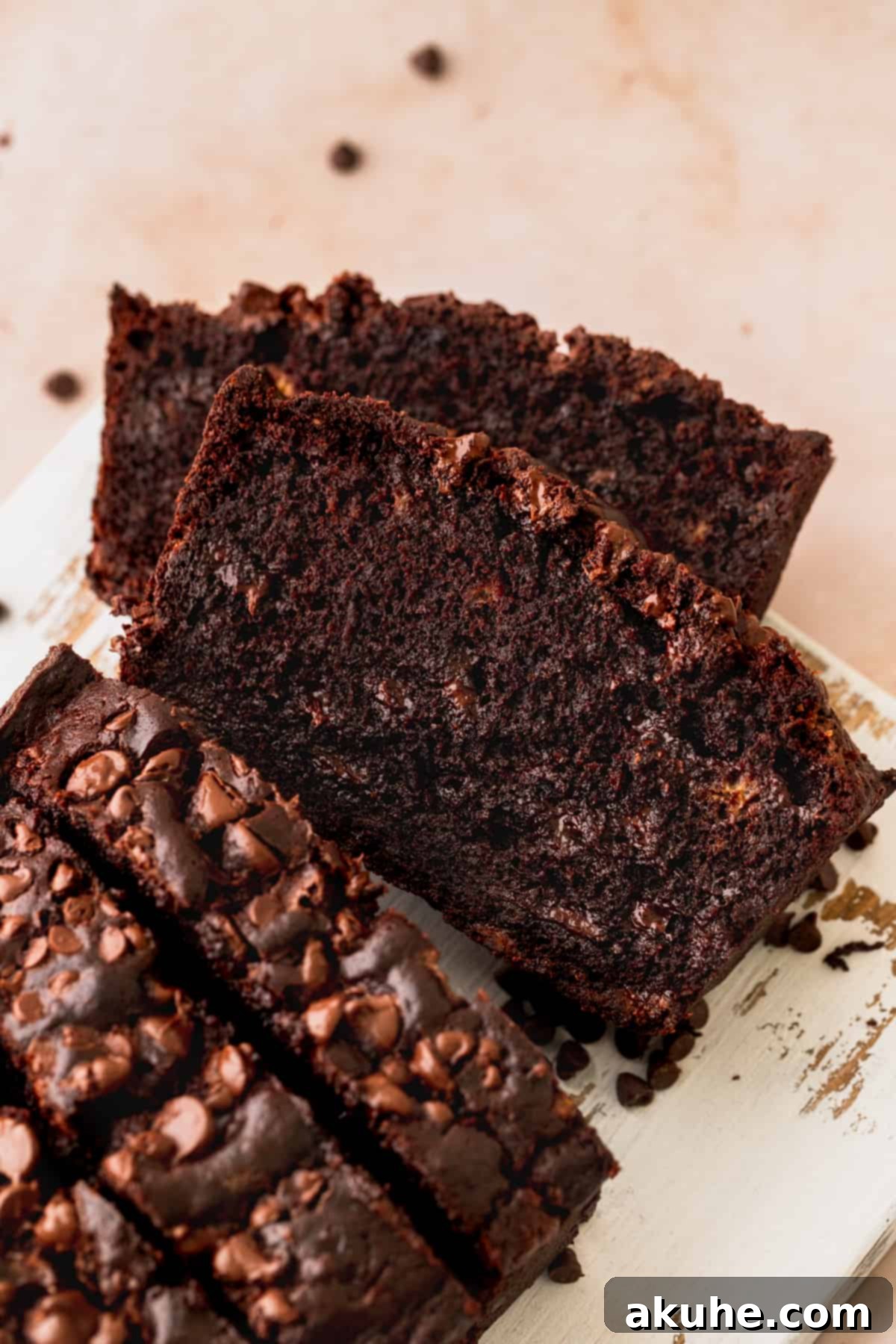 Decadent Double Chocolate Banana Bread 9 A white platter adorned with several slices of perfectly baked double chocolate banana bread, invitingly arranged.