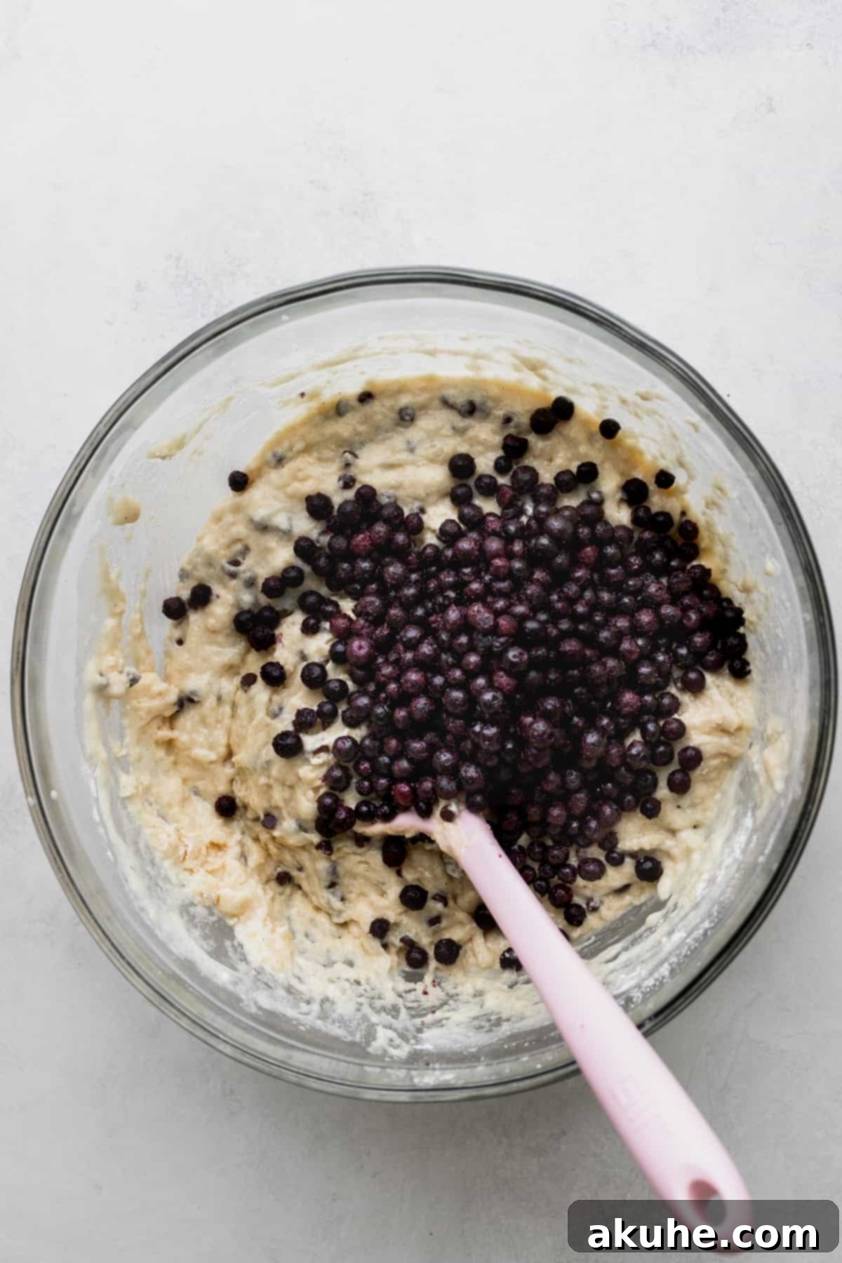 Ultimate Blueberry Chocolate Chip Muffins 5 Wild blueberries delicately placed on top of the muffin batter in a glass bowl, ready to be folded in.