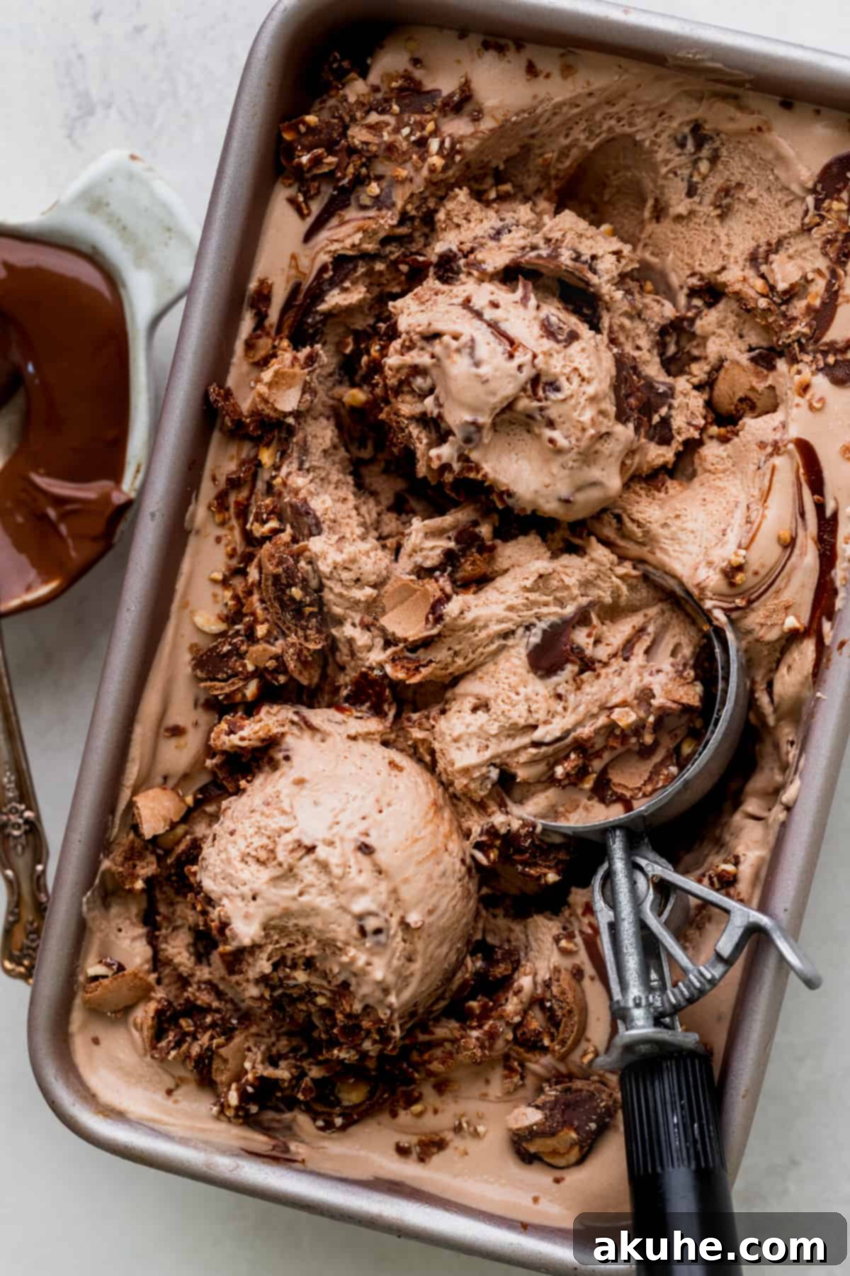 Nutella ice cream in a tin with an ice cream scoop, showcasing its creamy texture.