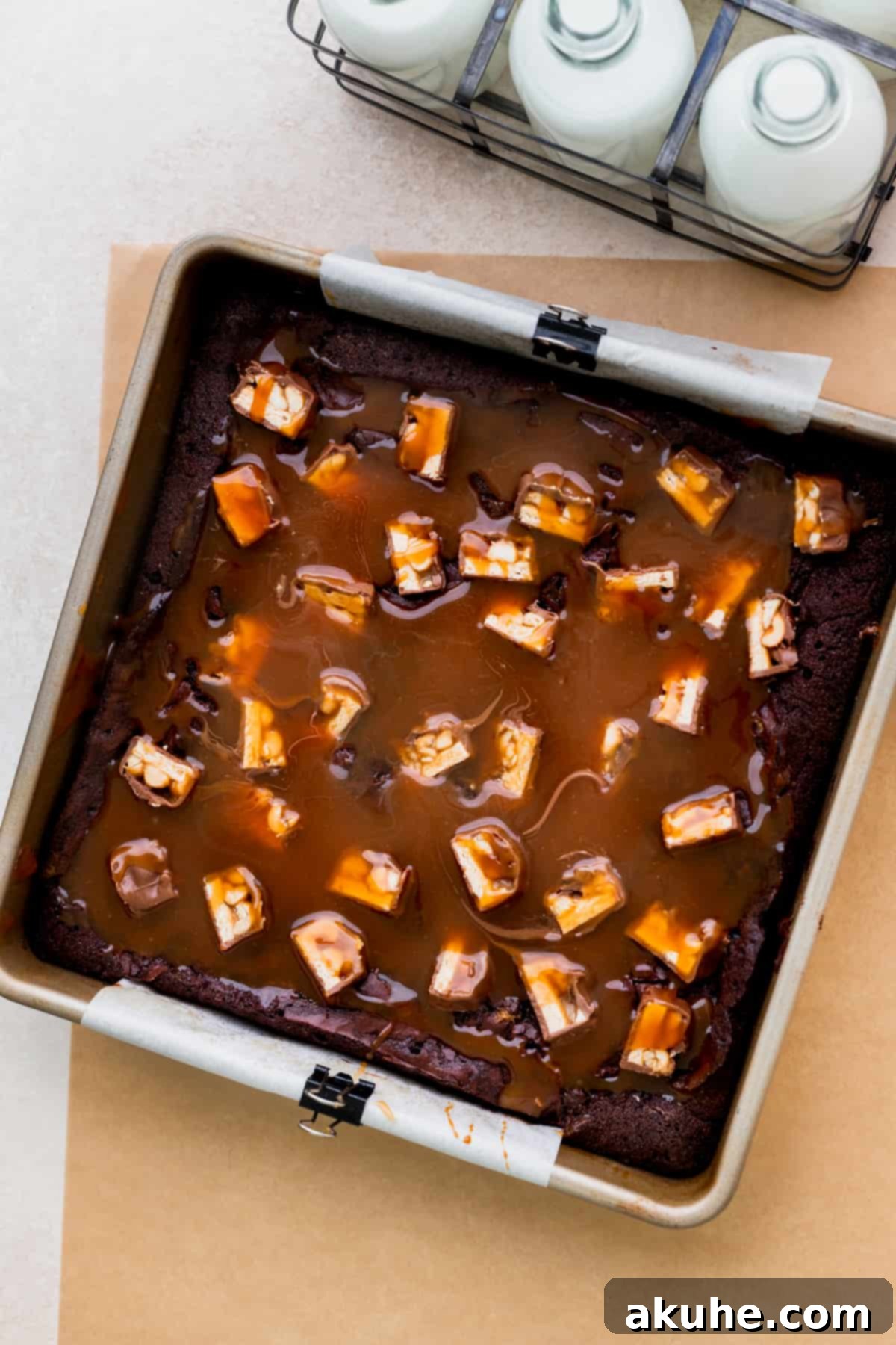 Snickers Brownies 9 Baked brownies with caramel on top in the pan.