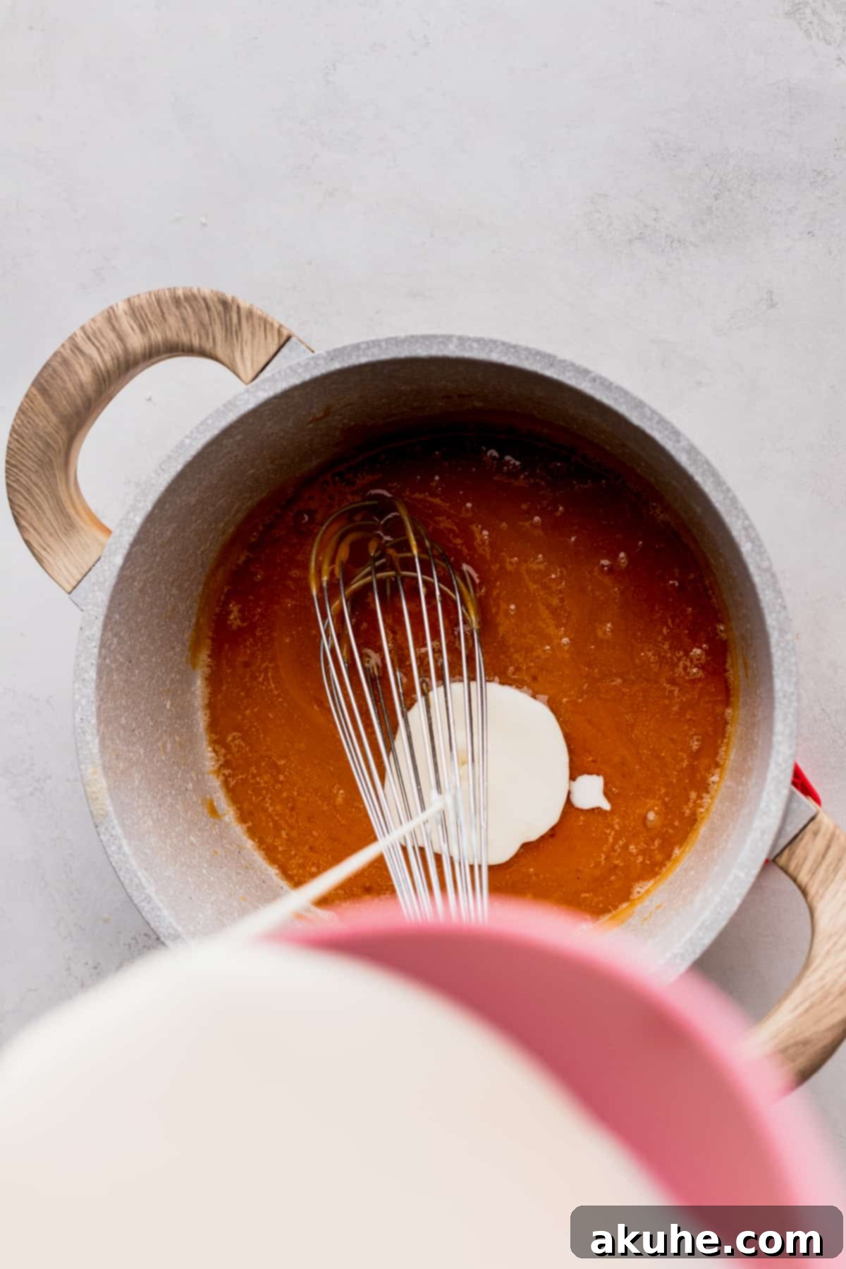 Homemade Salted Caramel Delights 7 Pouring heavy cream into a pot, creating steam and further bubbling.