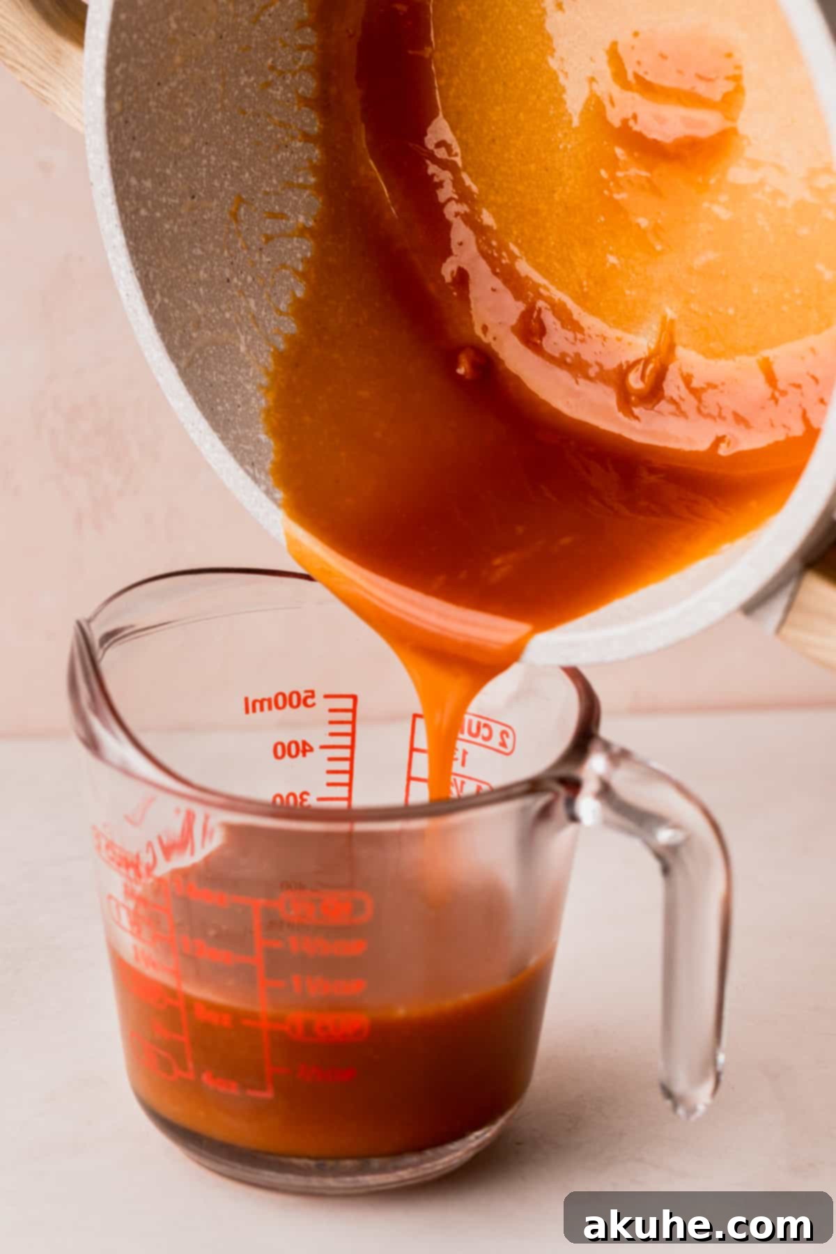 Homemade Salted Caramel Delights 8 Pouring hot caramel into a glass container for cooling.
