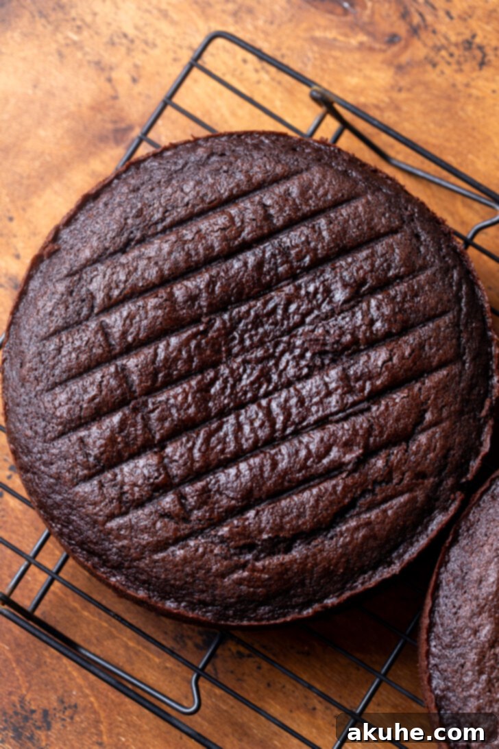 Decadent Triple Chocolate Cake 5 Baked cake on a wire rack.