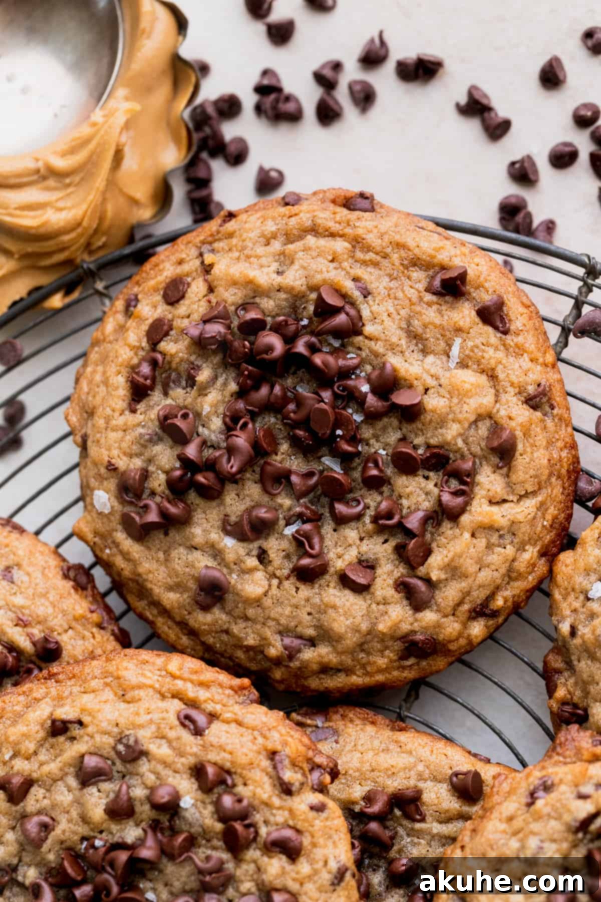 Close-up of a freshly baked banana peanut butter chocolate chip cookie on a cooling rack, showing its soft texture and melted chocolate.