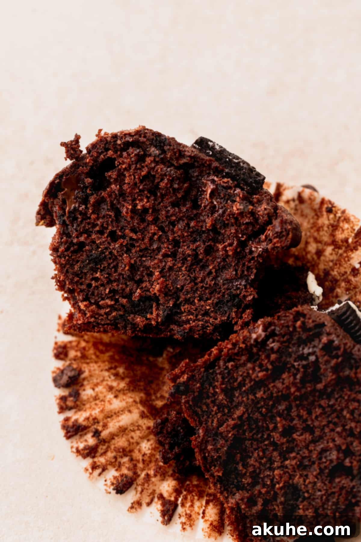 Decadent Oreo Delights 3 A delicious Oreo muffin, perfectly split in half, revealing its moist, chocolatey interior and generous chunks of Oreos and chocolate chips.