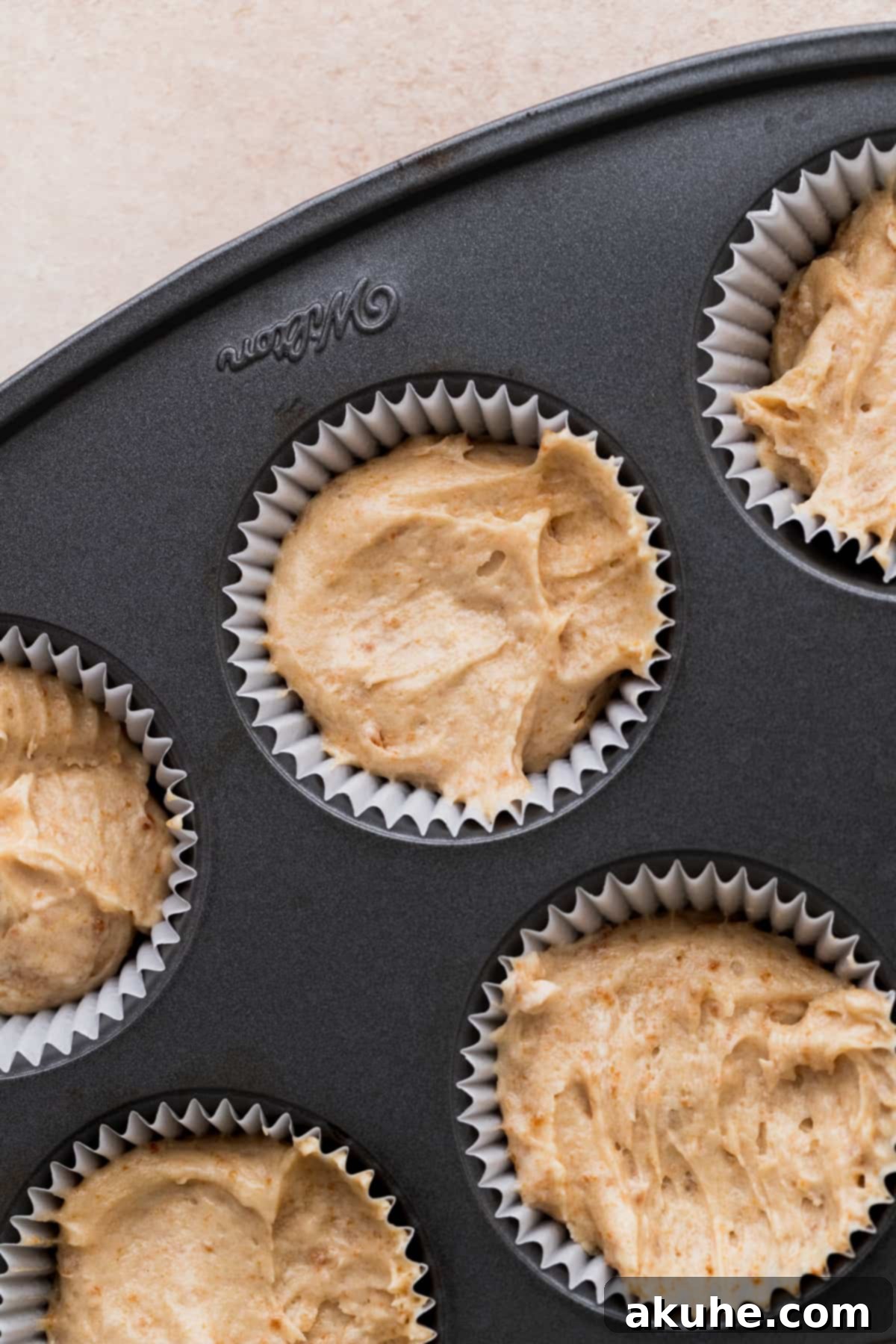 Irresistible Biscoff Cupcakes 7 Cupcake batter neatly scooped into liners in a cupcake pan, ready for the oven.