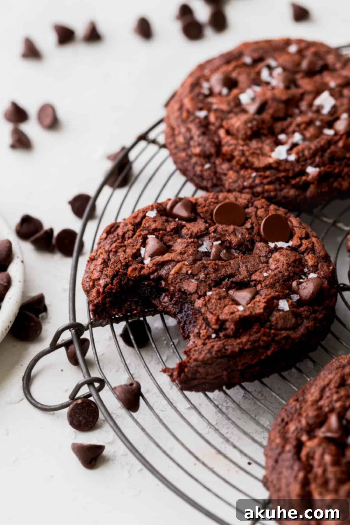 Ultimate Fudgy Crinkle Cookies 2 A bite missing from a brownie crinkle cookie, revealing its rich, fudgy interior and crinkled top.