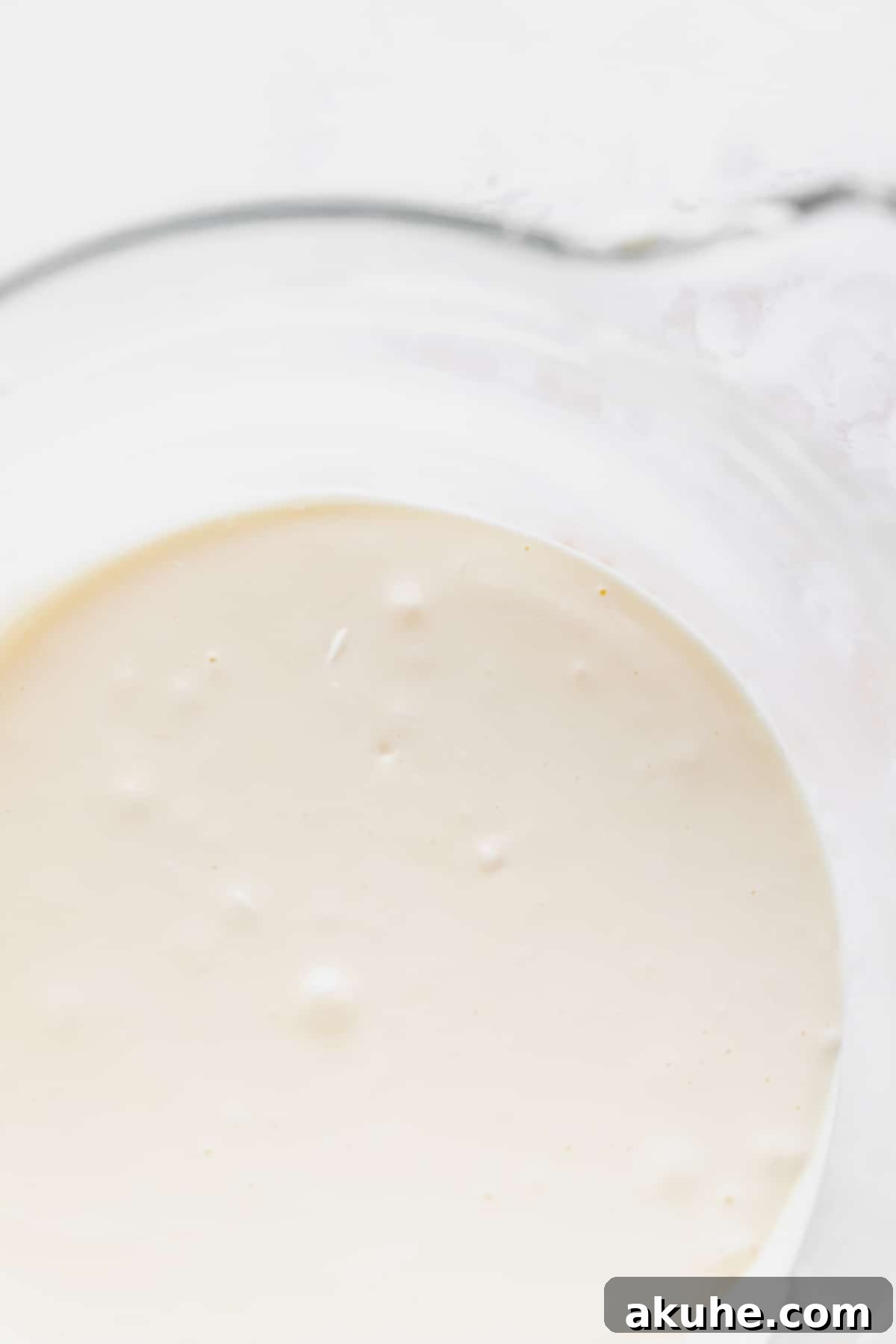 Decadent Cookie Dough Cheesecake Bars 4 Smooth, creamy cheesecake batter in a glass mixing bowl, perfectly prepared for the next steps.