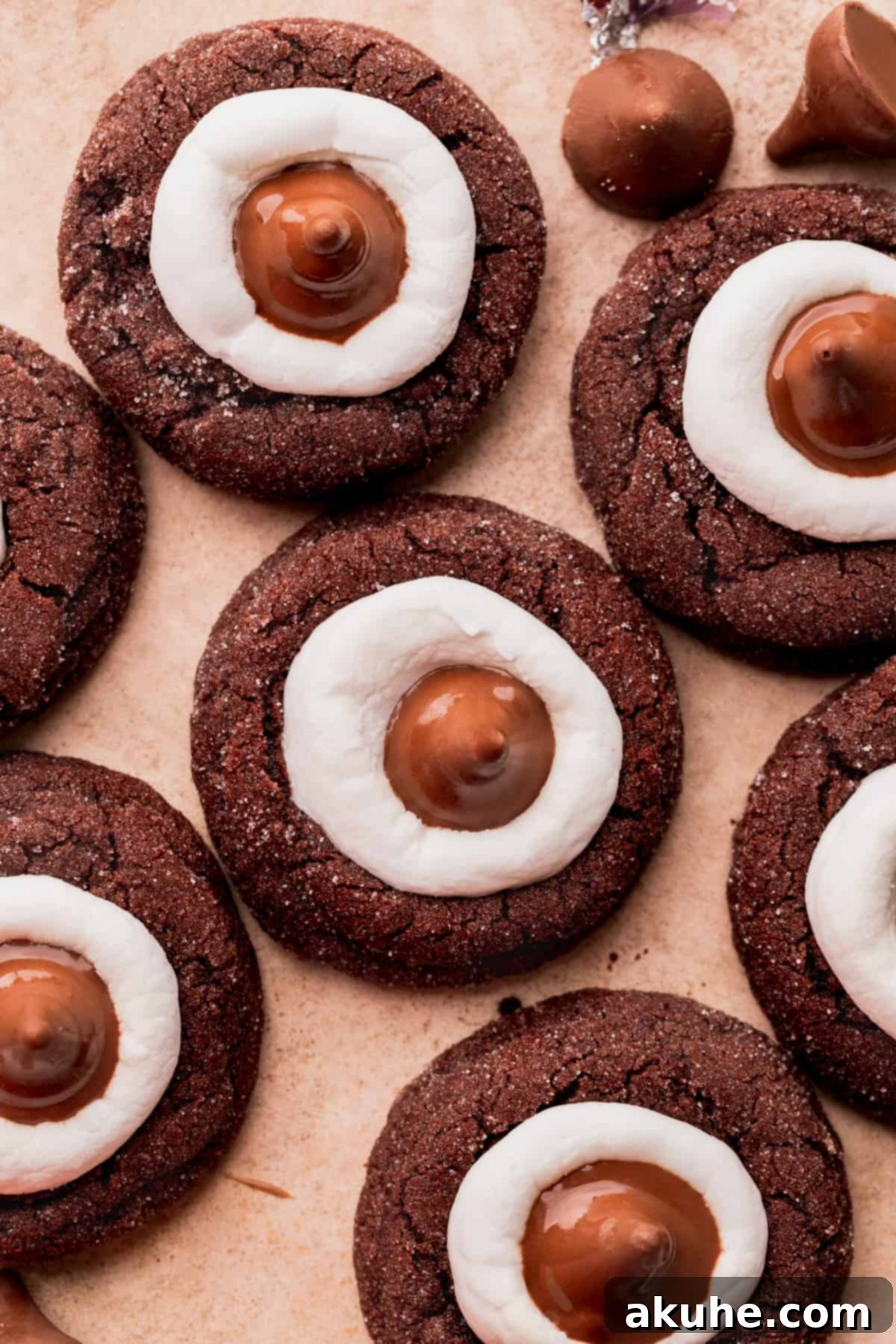 Warm Cocoa Blossom Cookies 12 Top-down view of multiple Hot Cocoa Cookie Blossoms arranged on a flat surface, highlighting their sparkling sugar coating and the perfect placement of Hershey's Kisses.