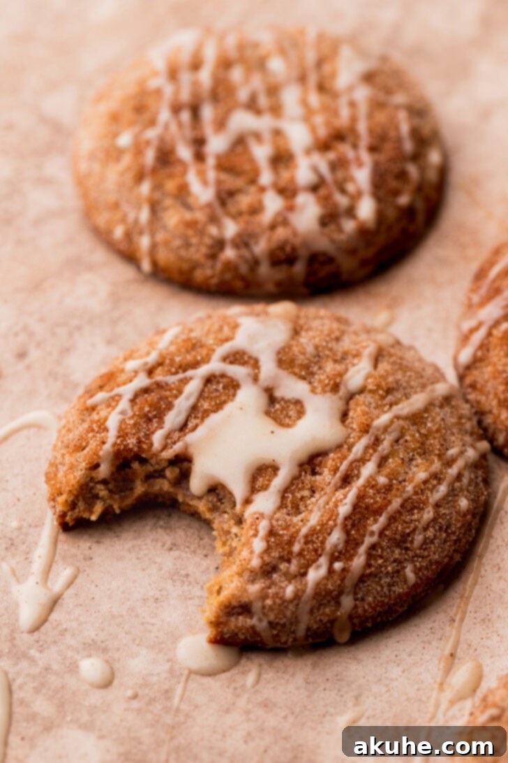 A perfectly baked apple cider cookie with a bite missing, showcasing its soft interior.