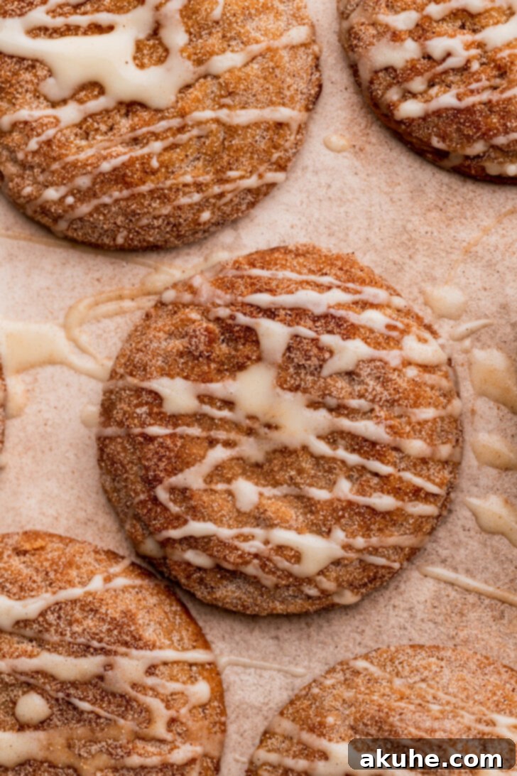 A close-up top view of freshly baked apple cider cookies, glistening with glaze and cinnamon sugar.