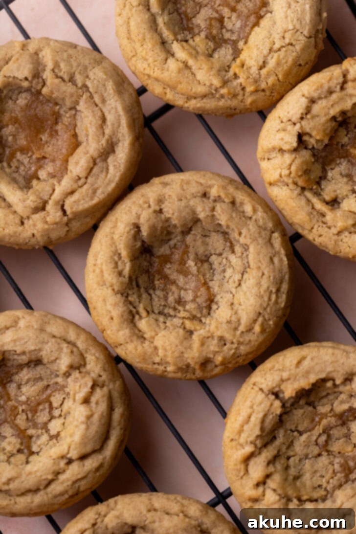 Spiced Apple Pie Cookies 9 Freshly baked cookies on a wire rack with indentations for filling.