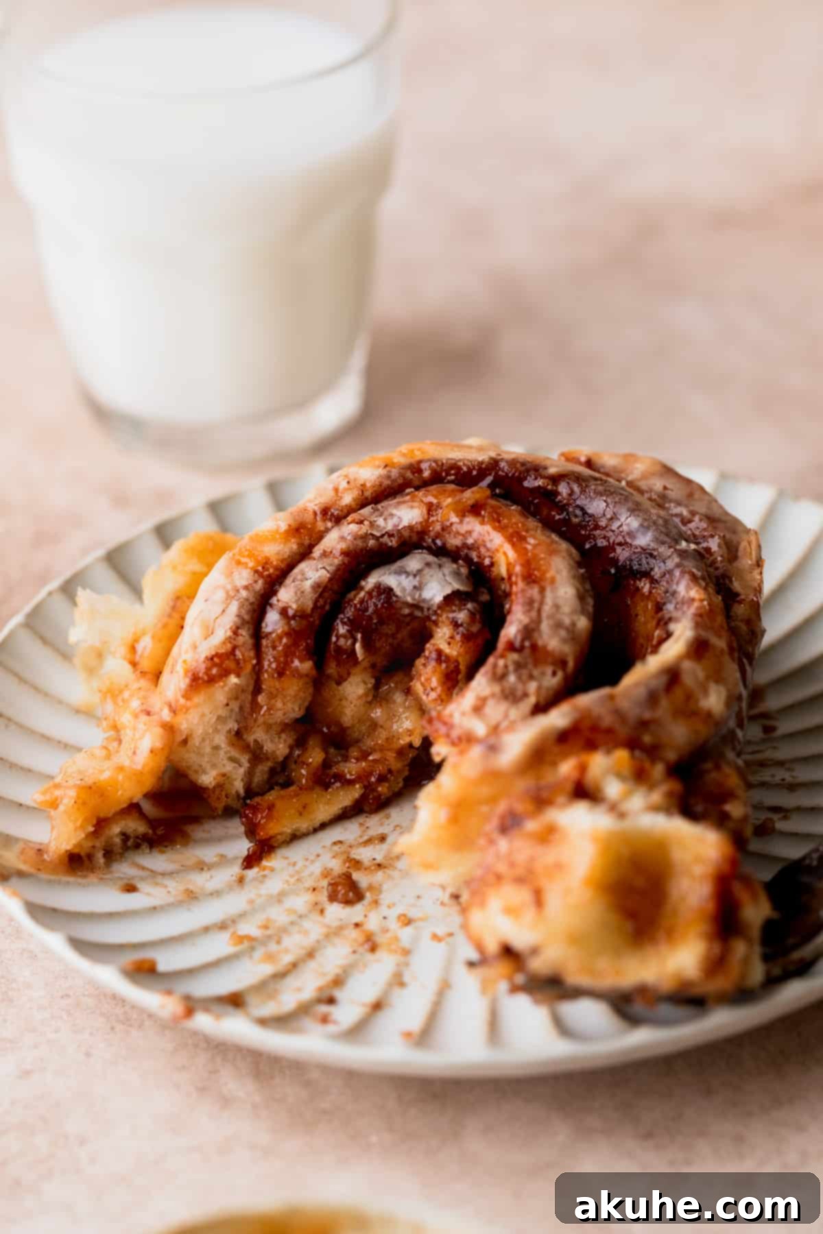 Decadent Caramel Cinnamon Rolls 15 A close-up of a caramel cinnamon roll with a bite taken out, revealing the gooey interior.