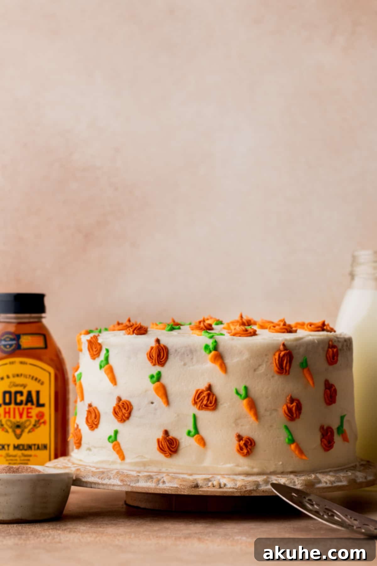 Beautifully decorated pumpkin carrot cake on a rustic wooden board, ready for serving.