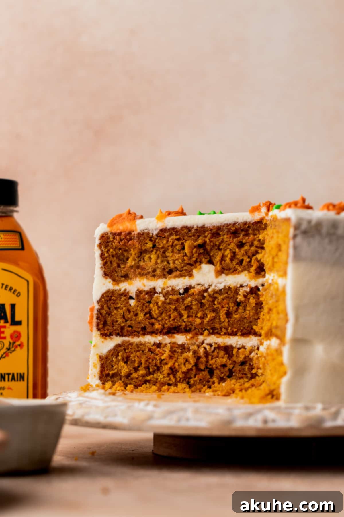 Close-up of a perfectly cut slice of pumpkin carrot cake, showing internal layers and moist texture.