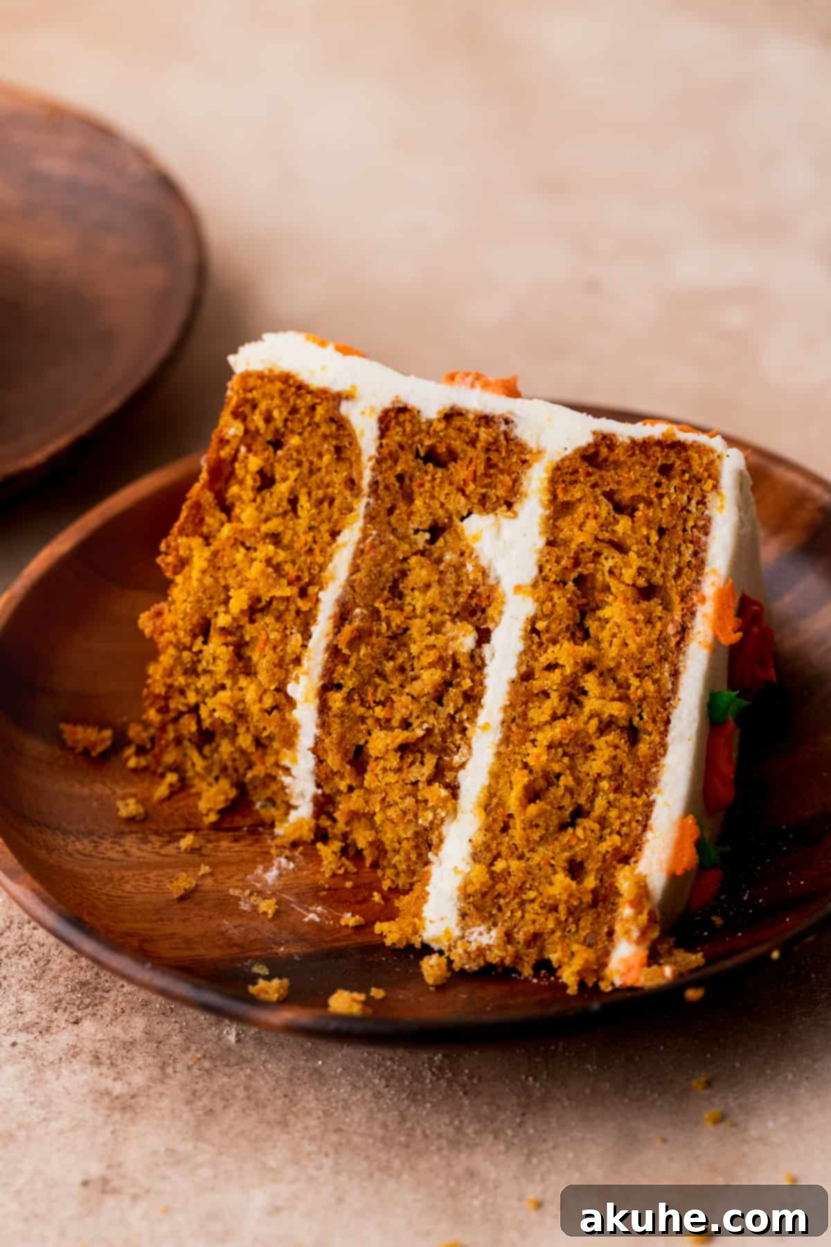 Close-up of a pumpkin carrot cake slice with a bite taken out, showing its delightful texture.