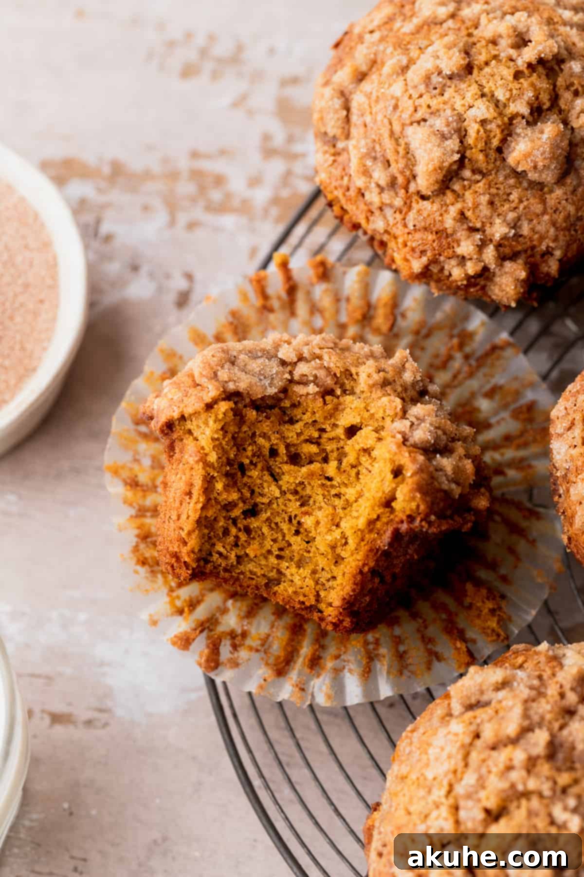Autumn Spiced Banana Pumpkin Muffins 2 A delicious pumpkin banana muffin with a bite taken out, showing its moist interior.