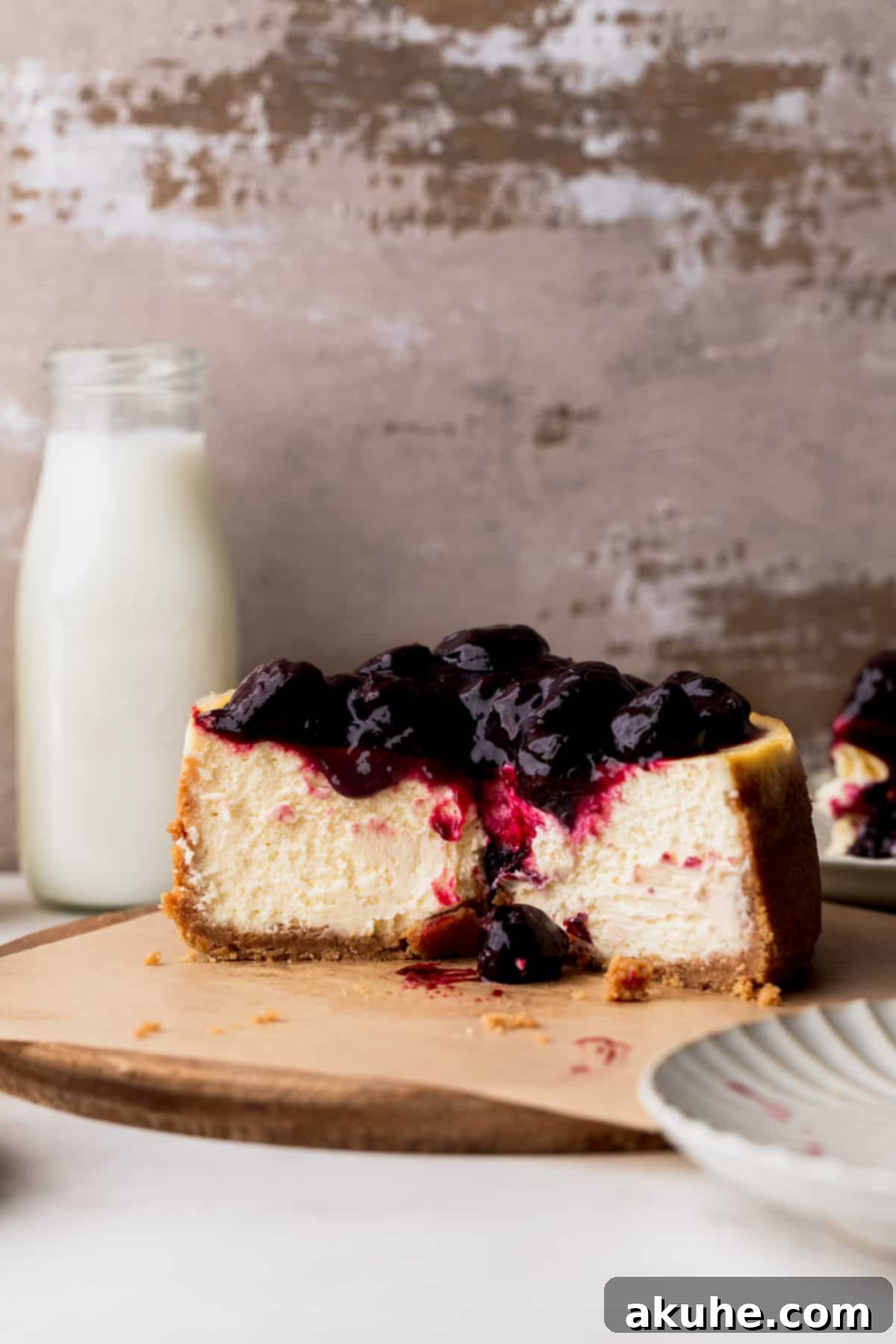 Mini Cheesecakes 2 Small cheesecake cut in half on a wood board, revealing its creamy texture.