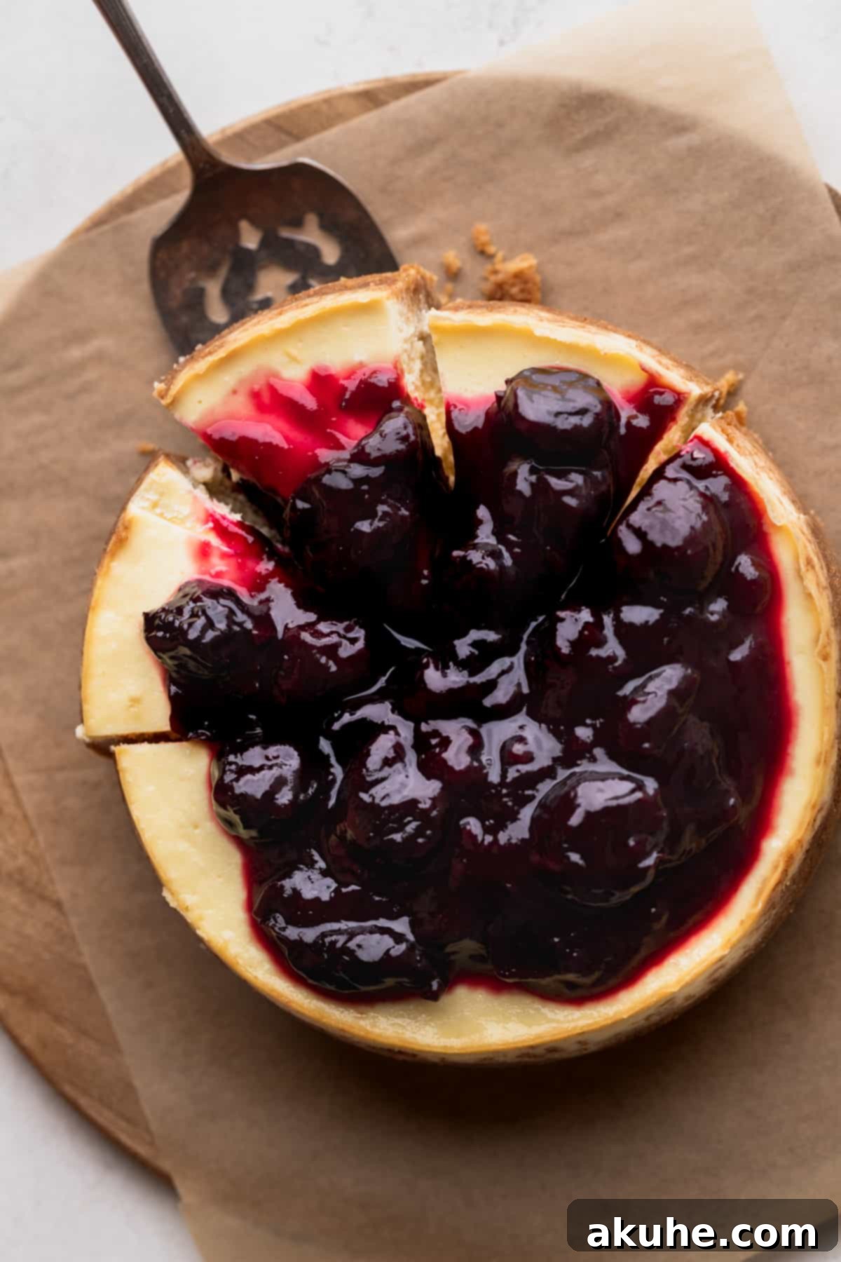 Mini Cheesecakes 12 Top view of a small cheesecake with three slices removed, showing its creamy interior.