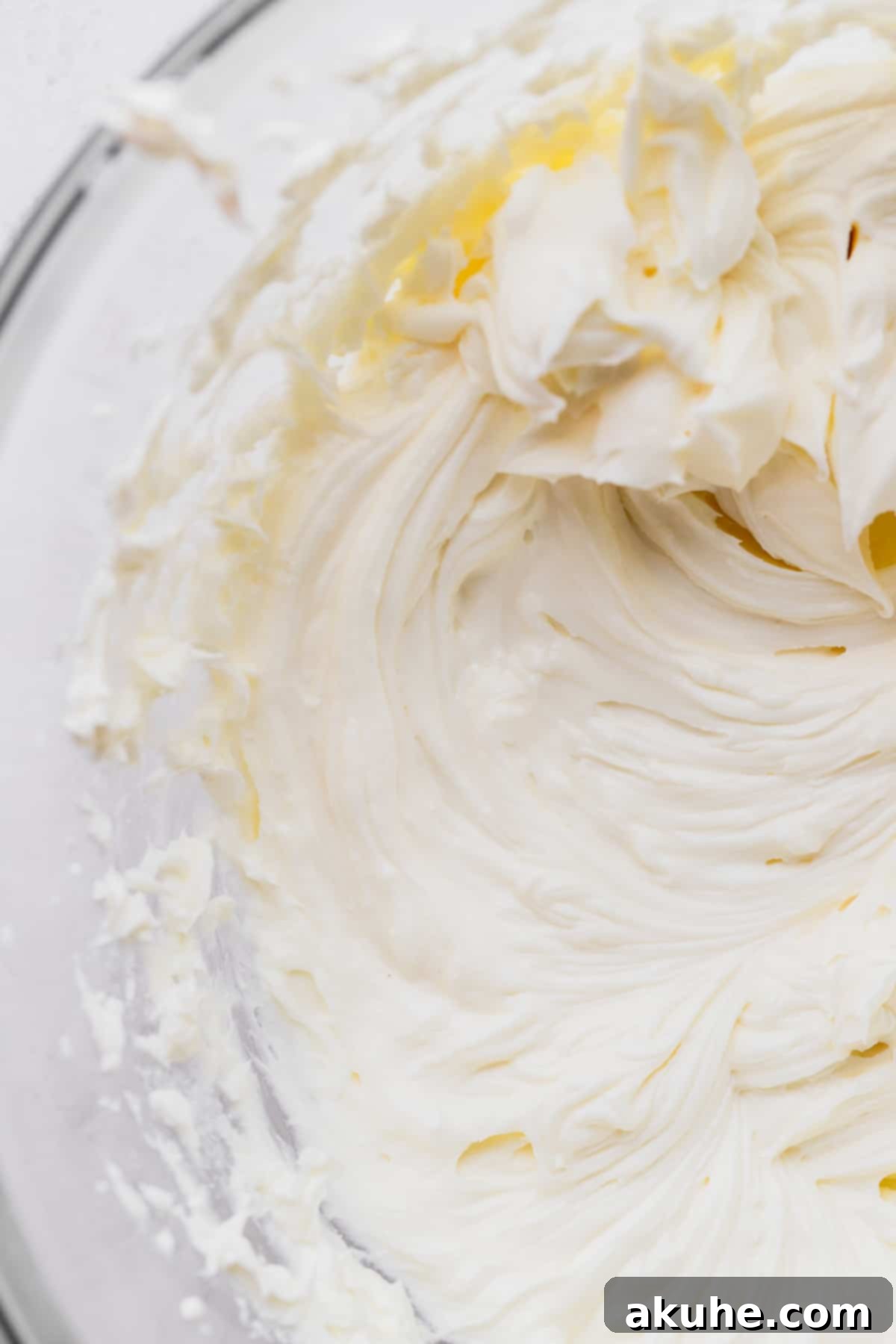 Mini Cheesecakes 6 Whipped cream cheese and sugar in a glass bowl, showing a creamy texture.