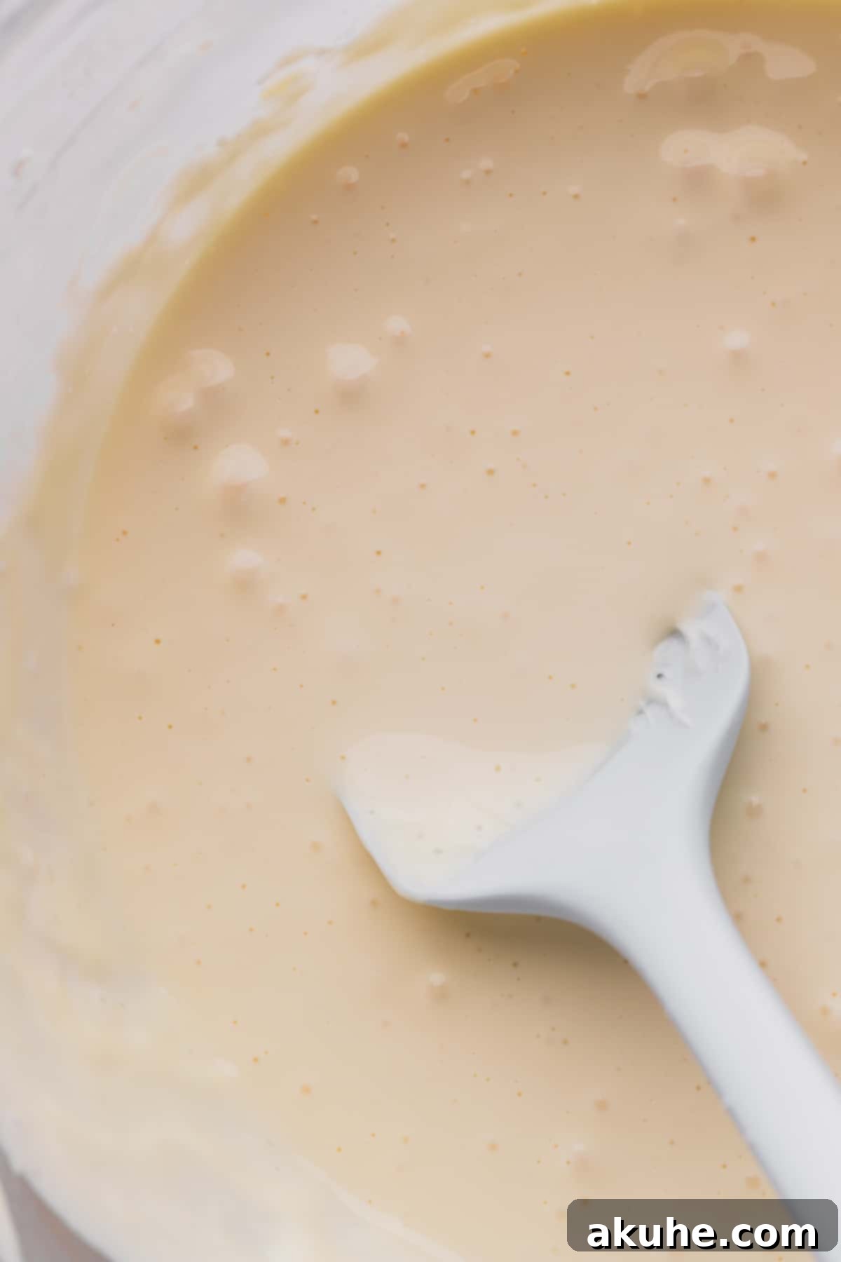 Mini Cheesecakes 7 Smooth cheesecake batter in a glass bowl, ready for pouring.