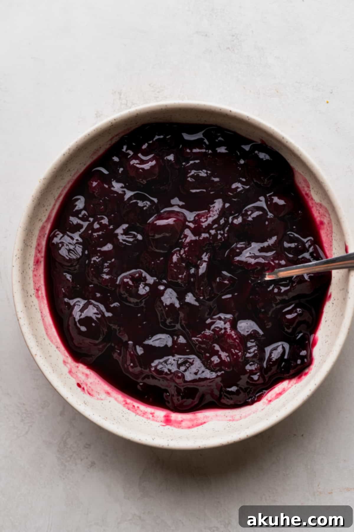Mini Cheesecakes 10 Homemade cherry pie topping in a bowl, showing its rich color and texture.
