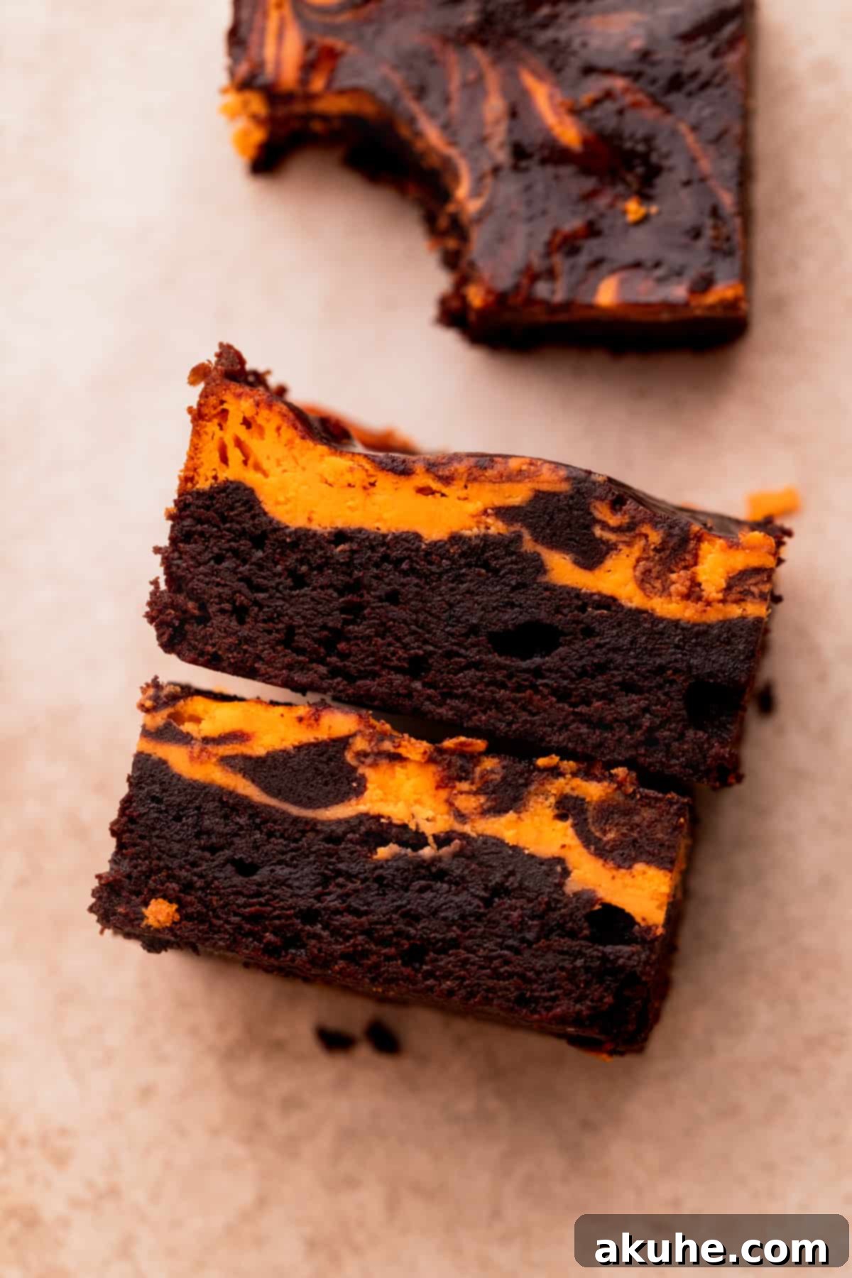 Two Halloween brownies standing on their sides, showcasing the fudgy interior and orange swirl.