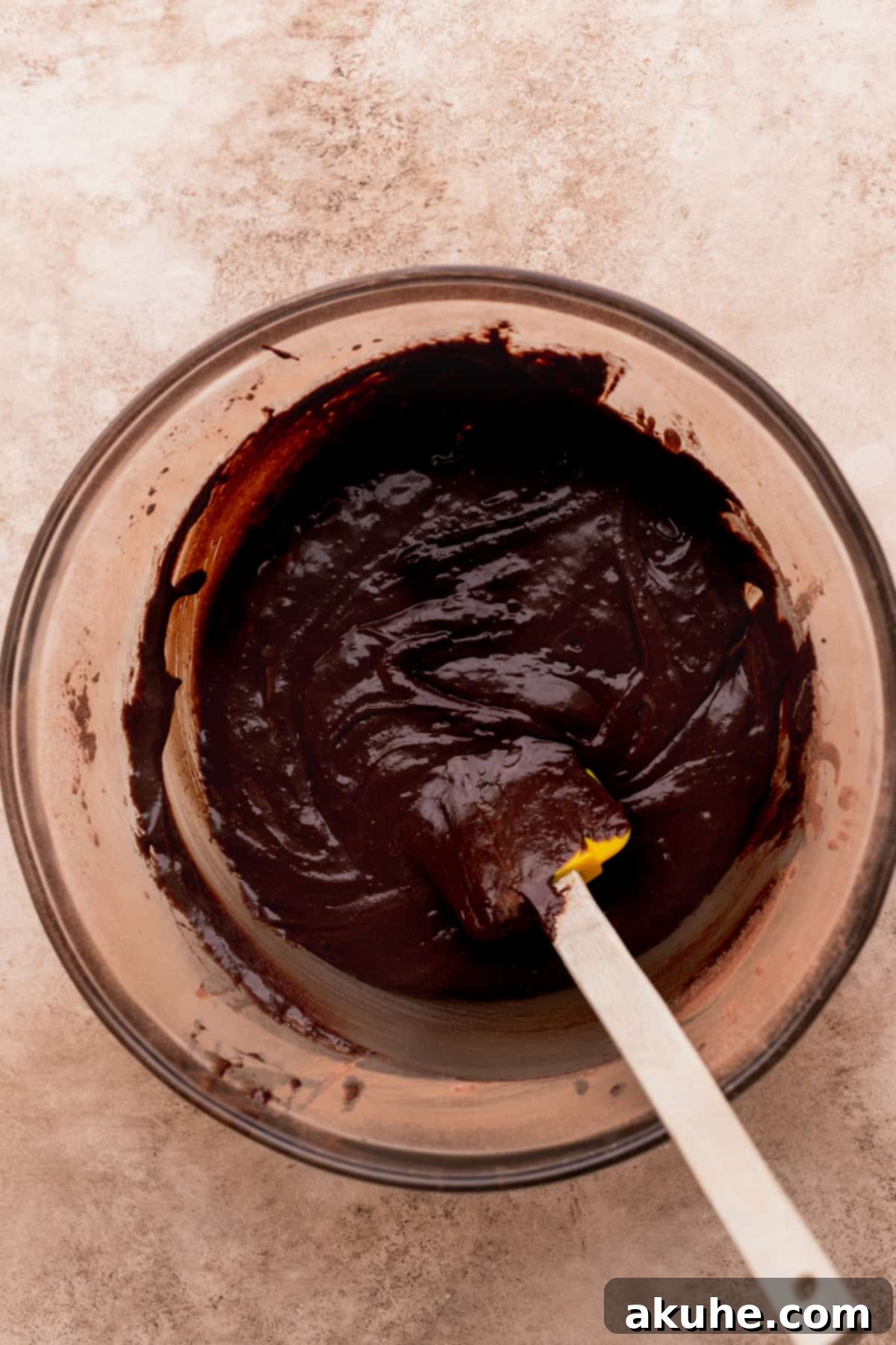 Rich, dark brownie batter in a glass bowl, ready for the pan.