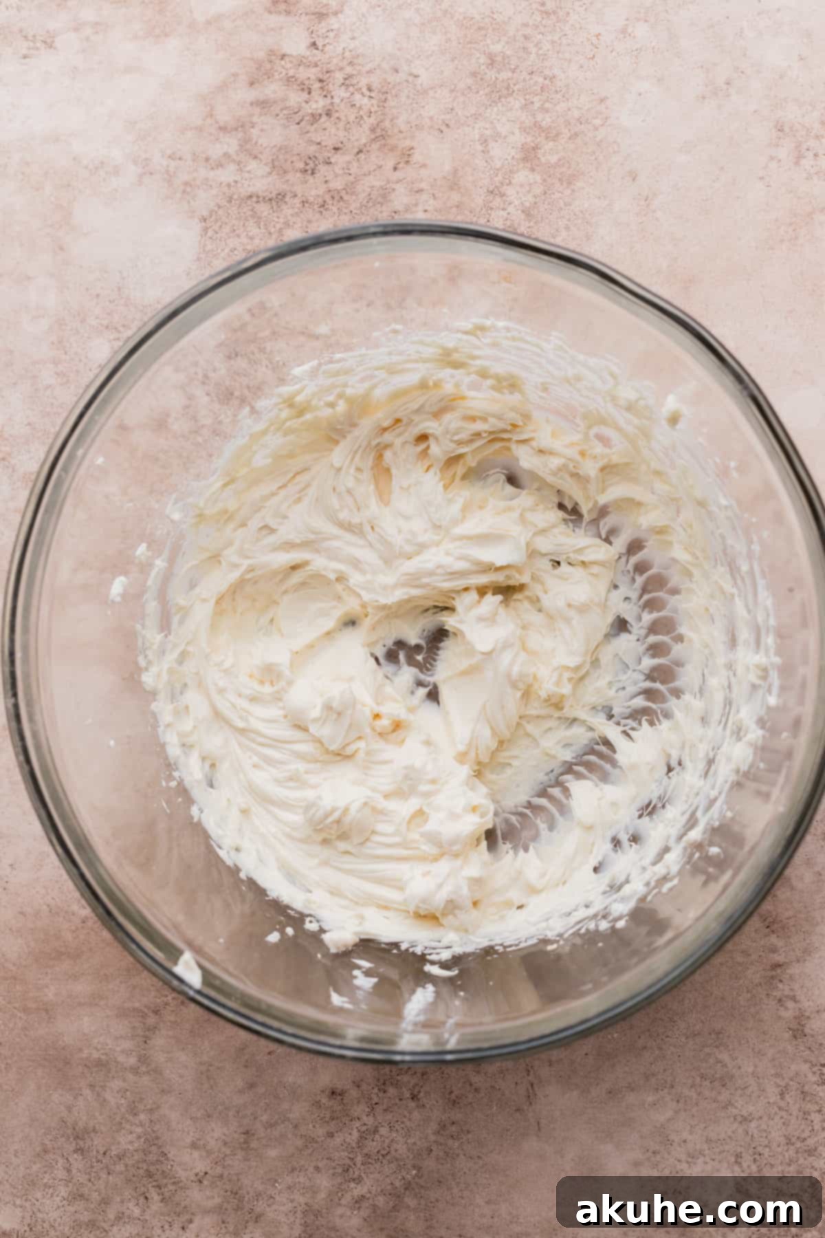 Creamy whipped cream cheese and sugar in a glass bowl.