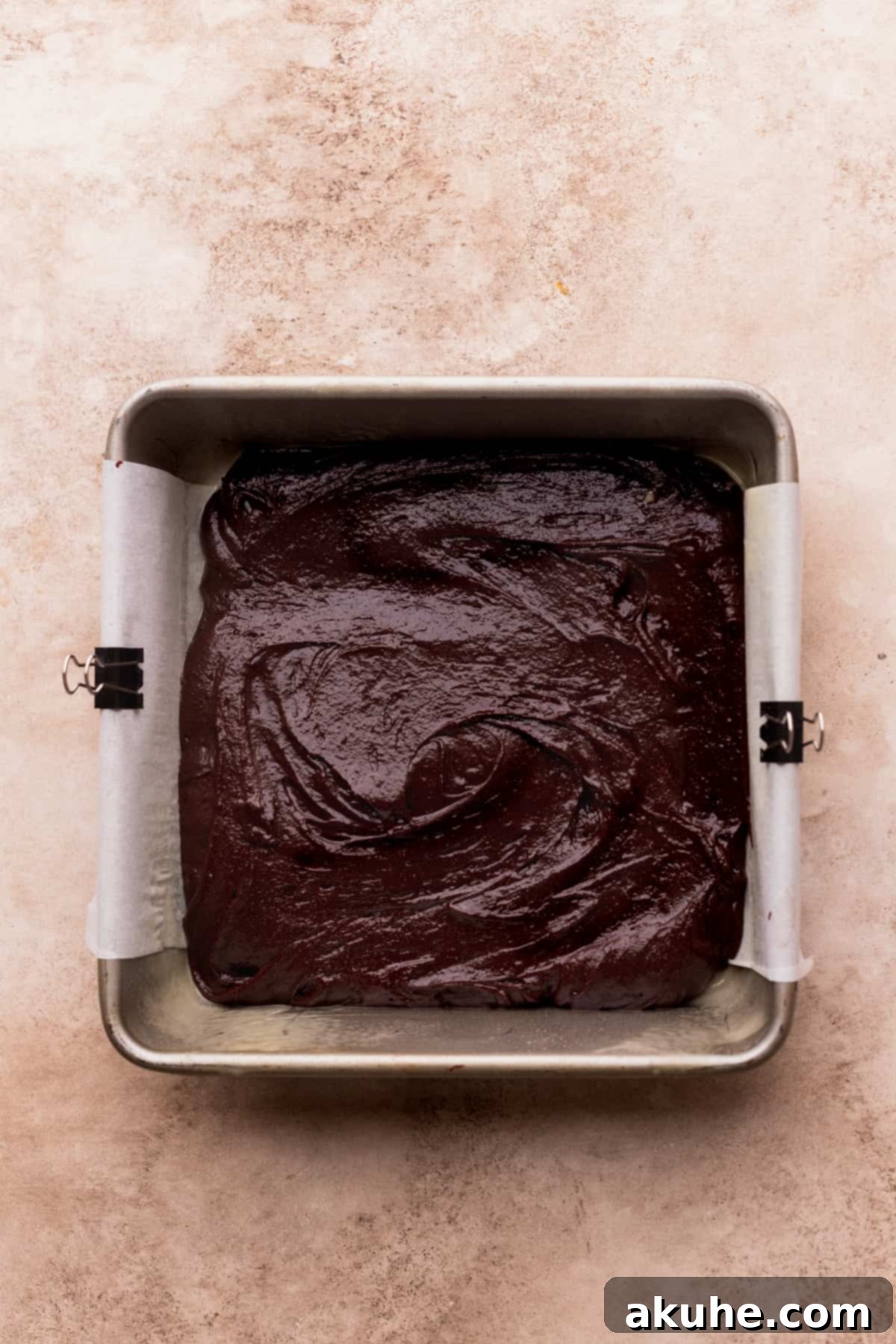 Brownie batter spread evenly in the prepared baking pan.