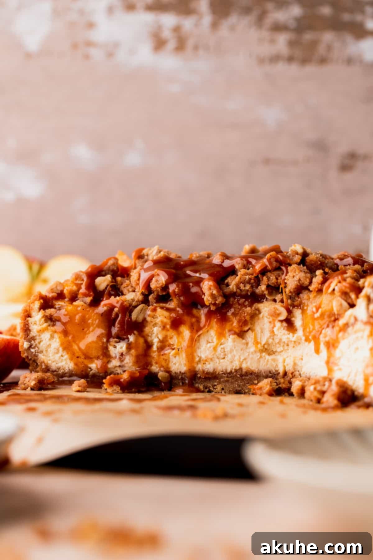 Ultimate Apple Crumble Cheesecake 14 A close-up view of a perfectly baked and sliced apple crumble cheesecake, showing the creamy texture and layers.