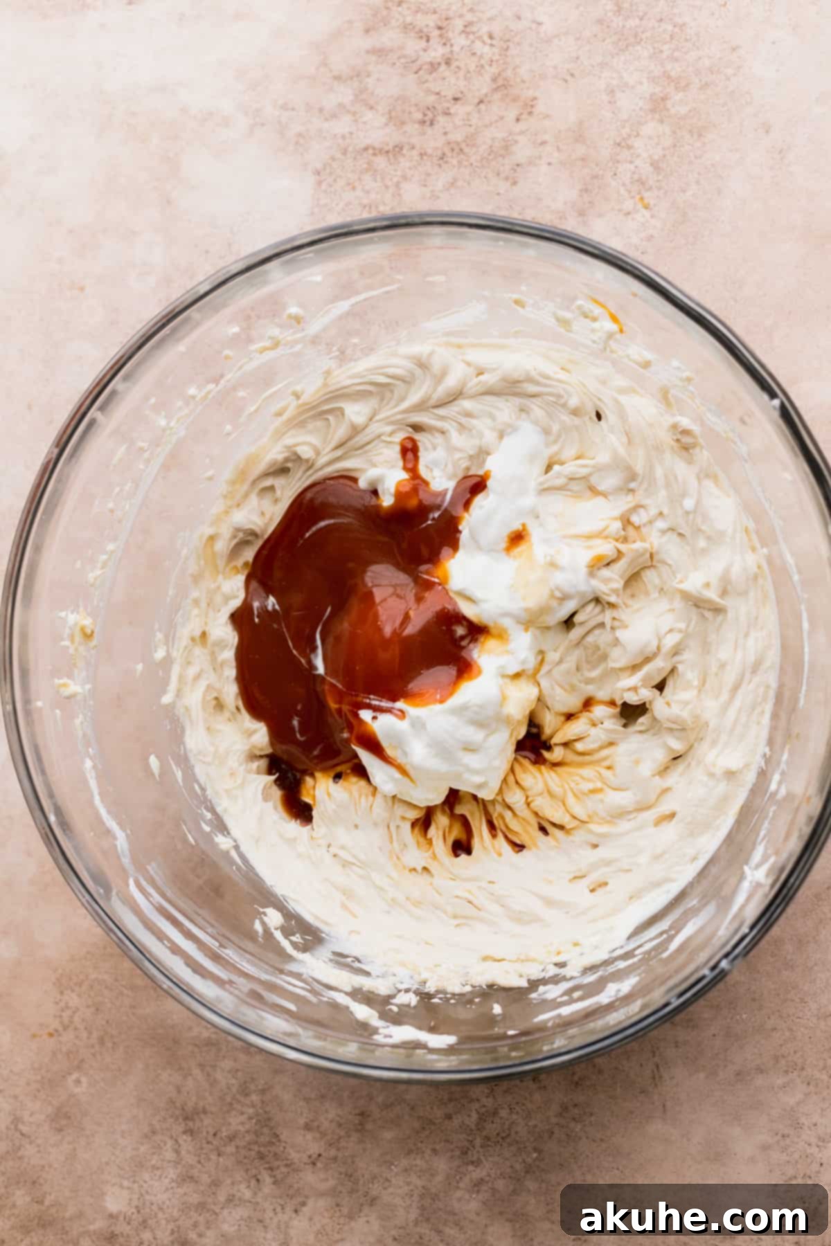 Ultimate Apple Crumble Cheesecake 4 Wet ingredients for cheesecake batter being mixed in a bowl.