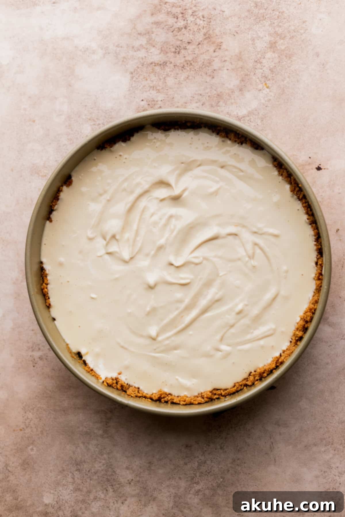 Ultimate Apple Crumble Cheesecake 7 Creamy cheesecake batter poured into the cinnamon graham cracker crust in a springform pan, ready for baking.