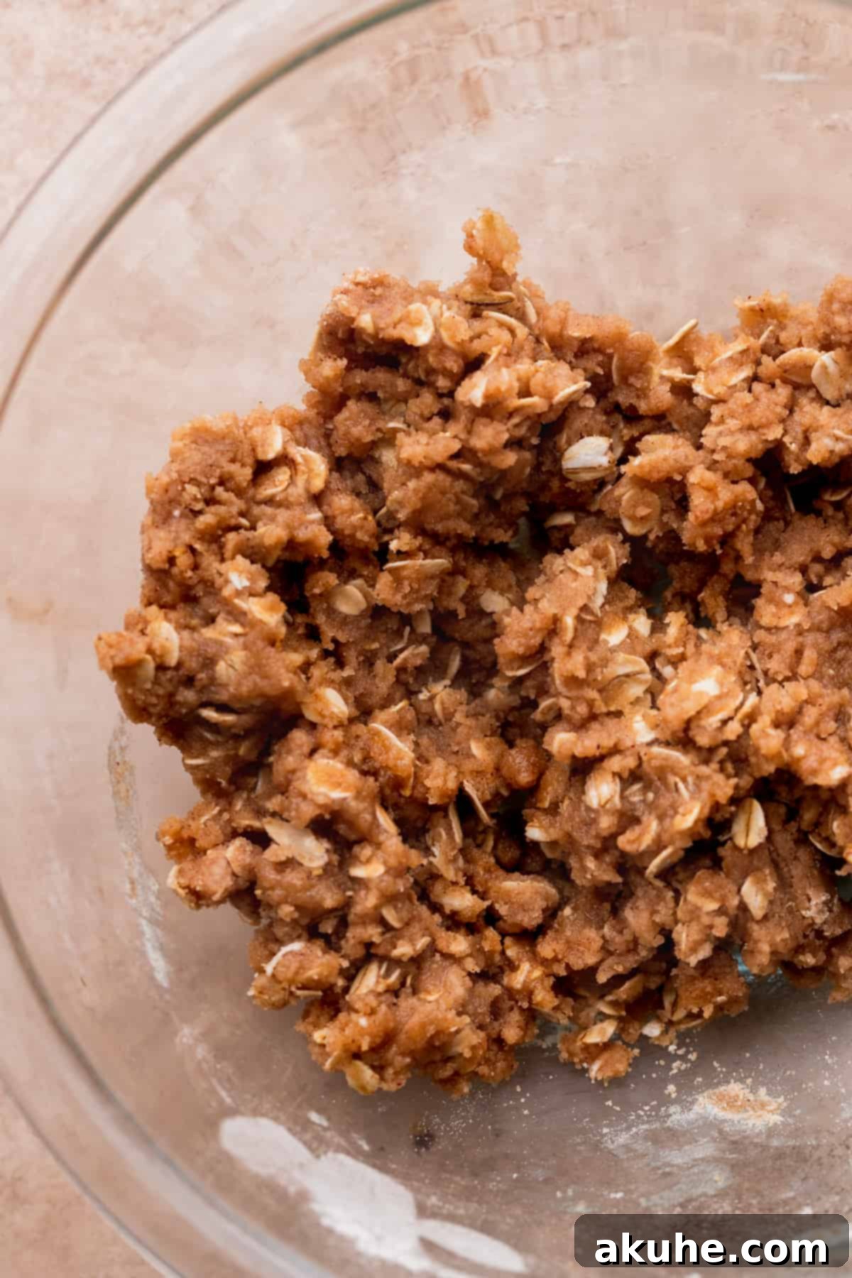 Ultimate Apple Crumble Cheesecake 8 Close-up of cinnamon oat crumble mixture in a bowl, ready for baking.