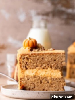 Chai Spiced Cake 11 Slice of chai cake on a plate standing up, showing distinct layers and frosting.