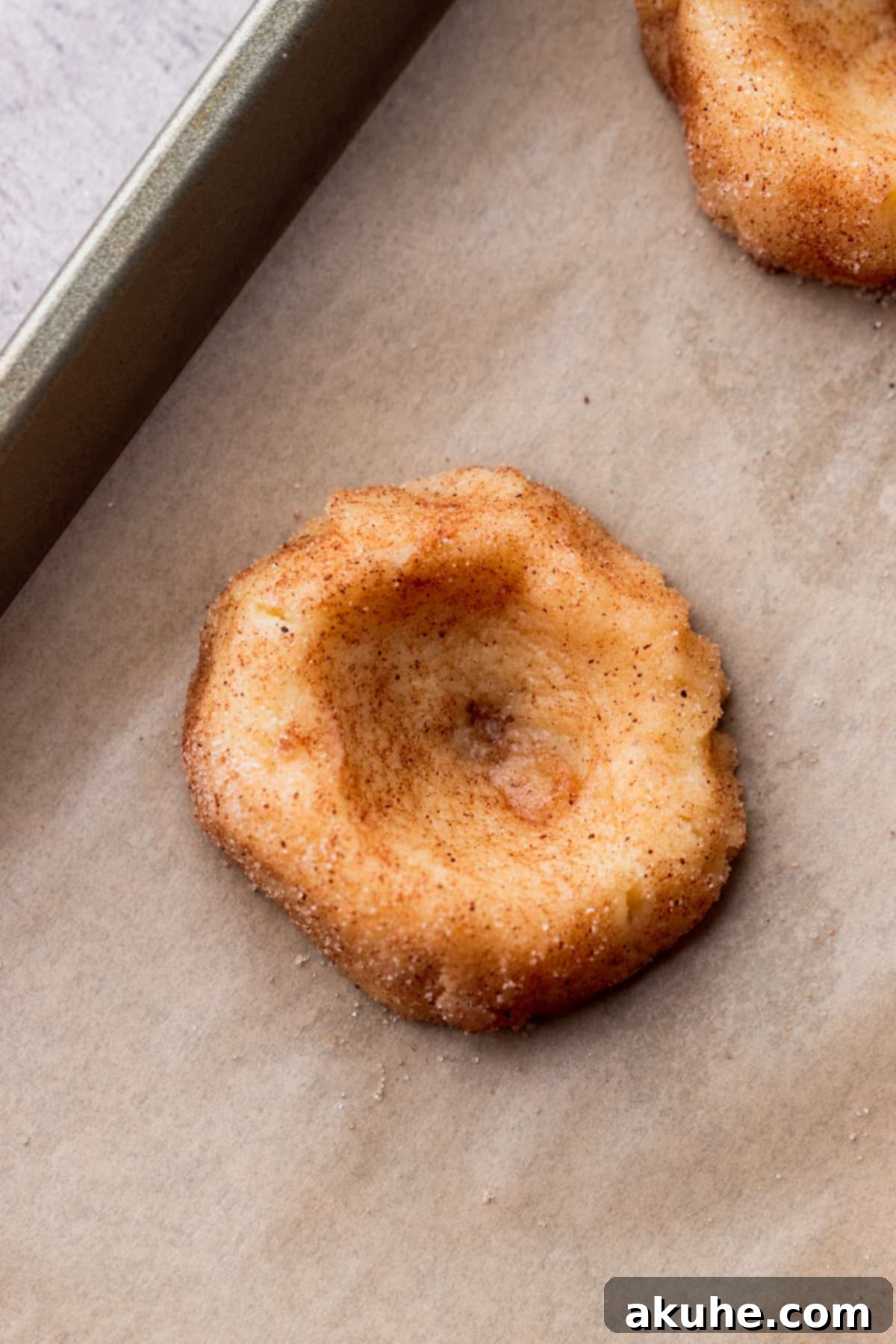 A cookie dough ball with a well-formed indentation in the center, ready for filling.