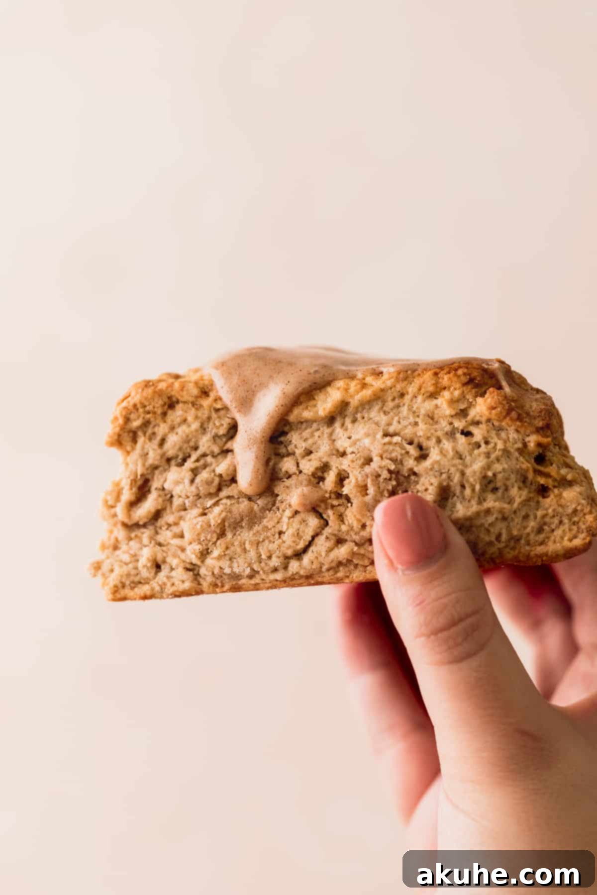 Banana Bread Scones 3 A baker holding up a freshly baked cinnamon banana scone, showing its soft interior.