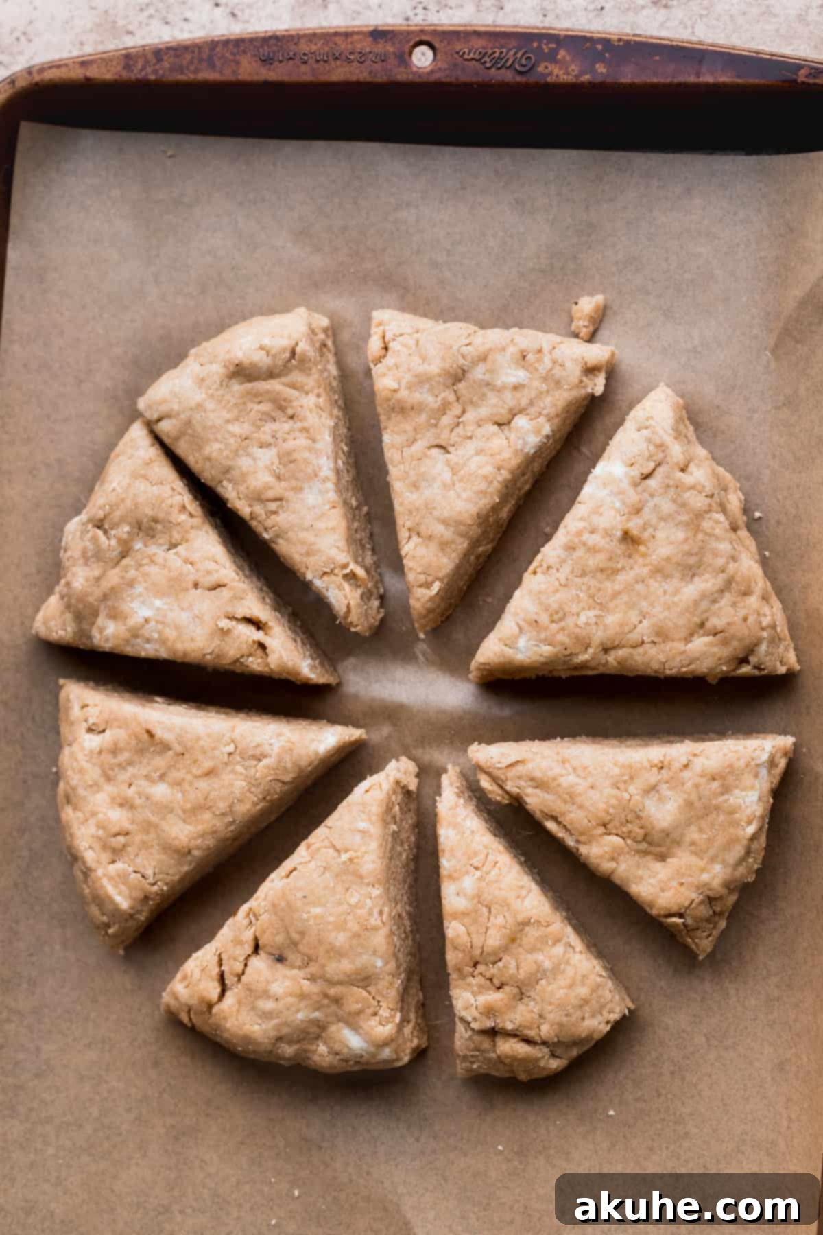 Banana Bread Scones 8 Cut scone triangles separated on parchment paper, ready for freezing.