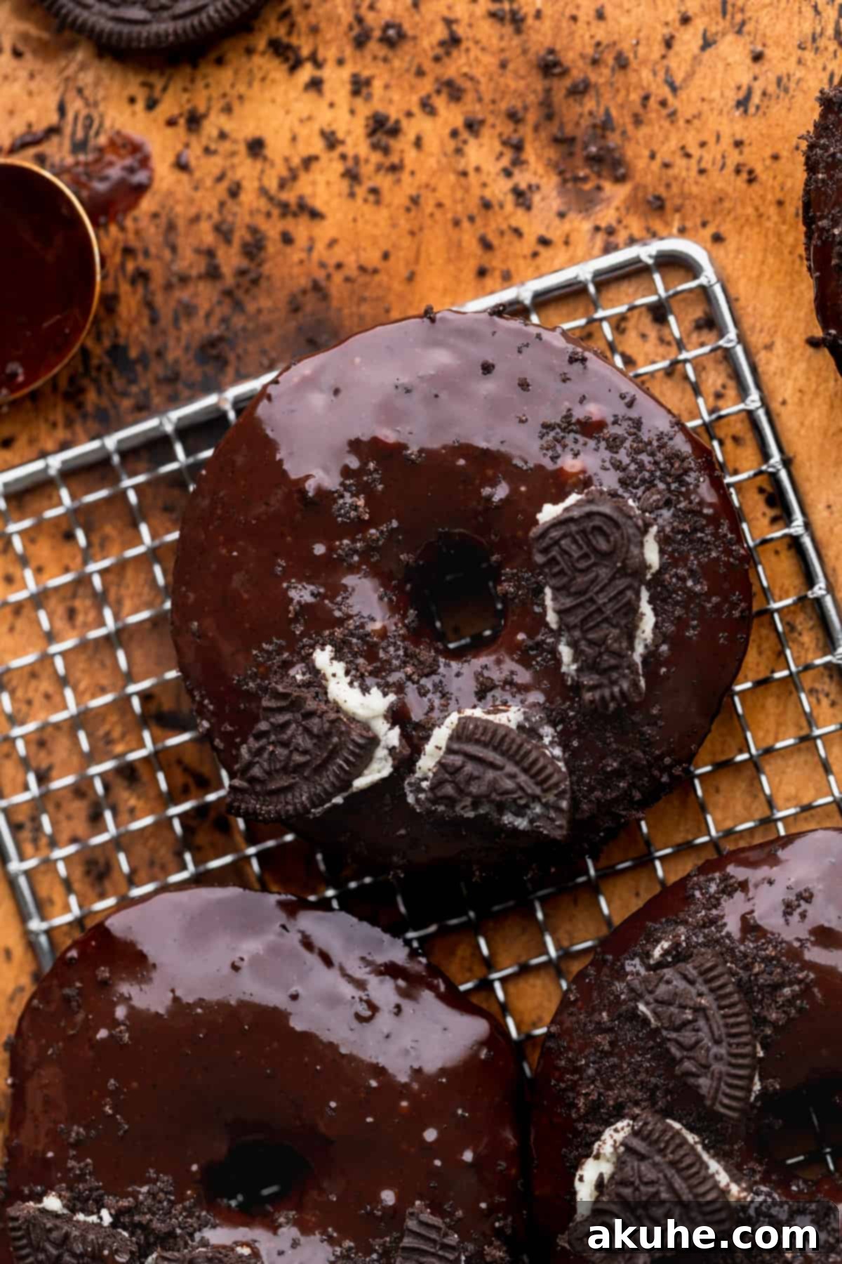 Cookies and Cream Doughnuts 2 Close up of Oreo donuts on a wire rack, showcasing their rich color and glaze.