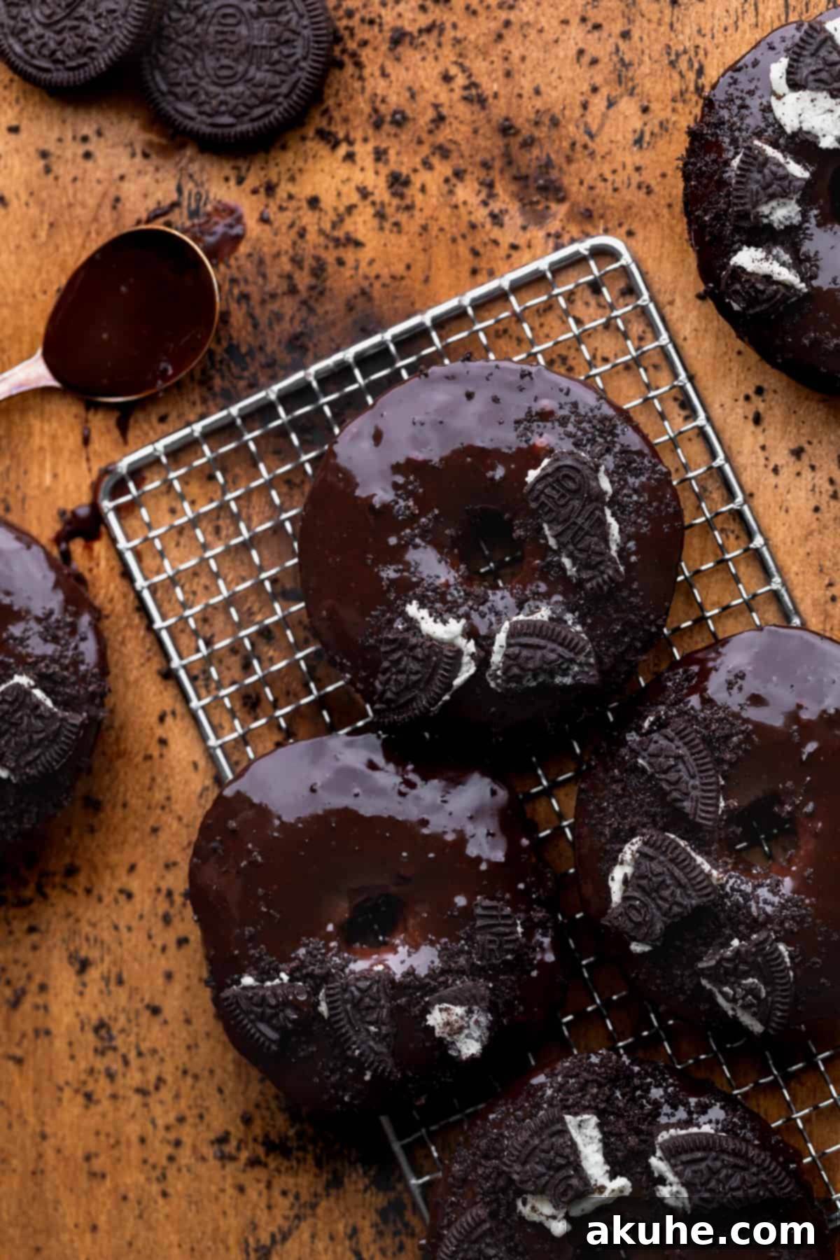 Cookies and Cream Doughnuts 3 Freshly baked Oreo donuts cooling on a wire rack.