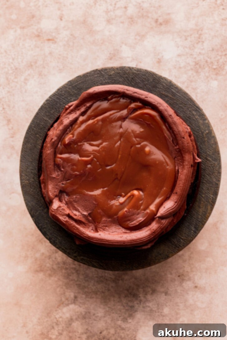 Ultimate Twix Cake 7 Layer of cake with chocolate frosting, piped border, and drizzled caramel.