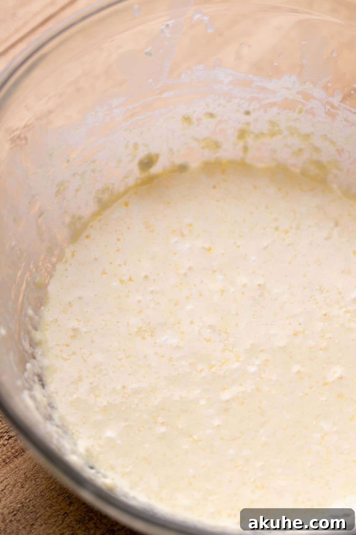 Decadent Chocolate Donut Delights 4 A bowl filled with whisked wet ingredients for donut batter, including eggs, milk, sour cream, and melted butter.