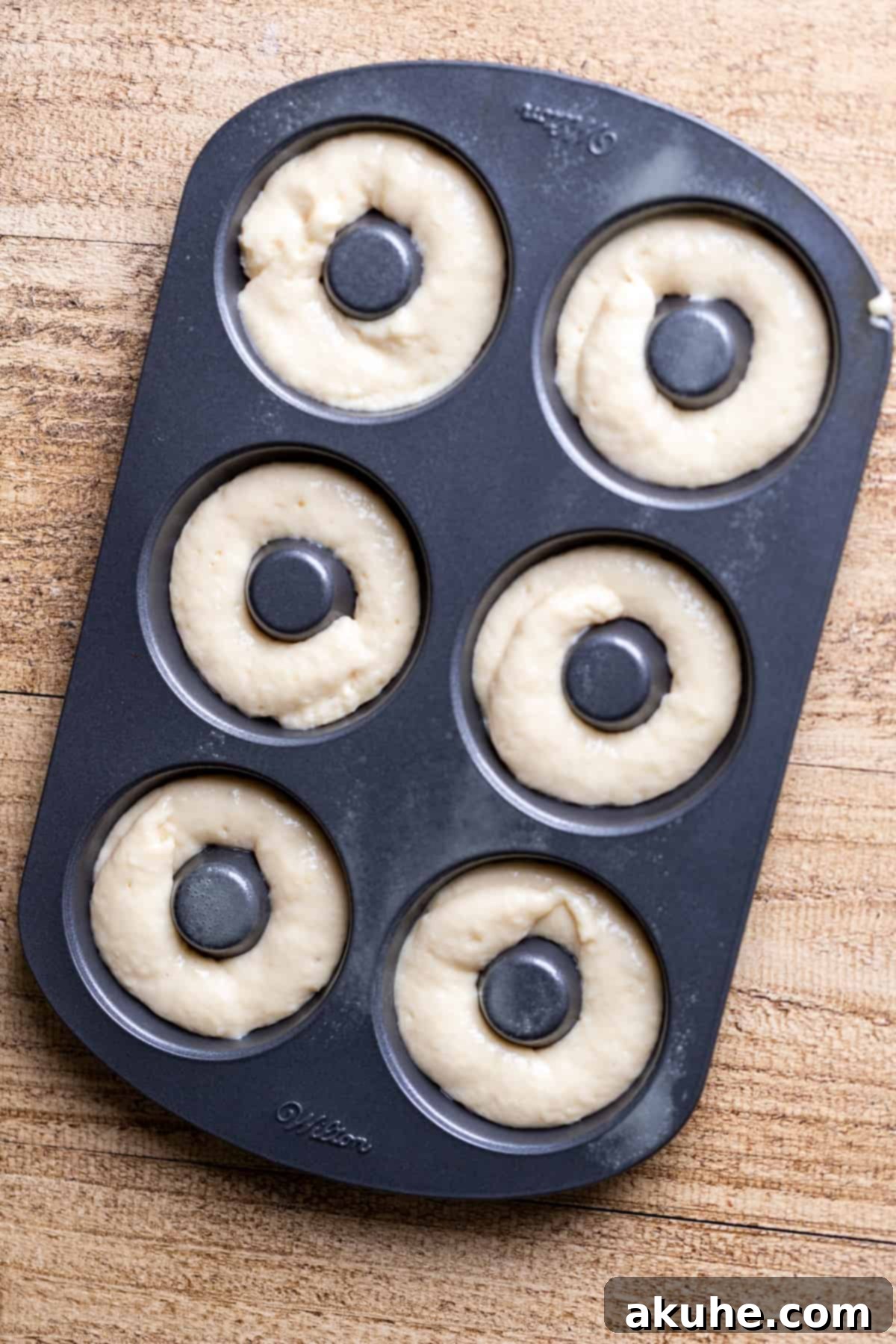 Decadent Chocolate Donut Delights 6 Donut batter carefully piped into a donut pan, filling each cavity evenly before baking.