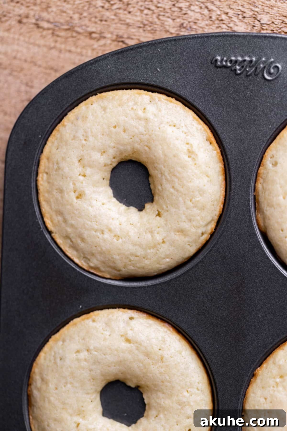 Decadent Chocolate Donut Delights 7 Freshly baked donuts resting in a donut pan, displaying their golden-brown color and perfect shape.