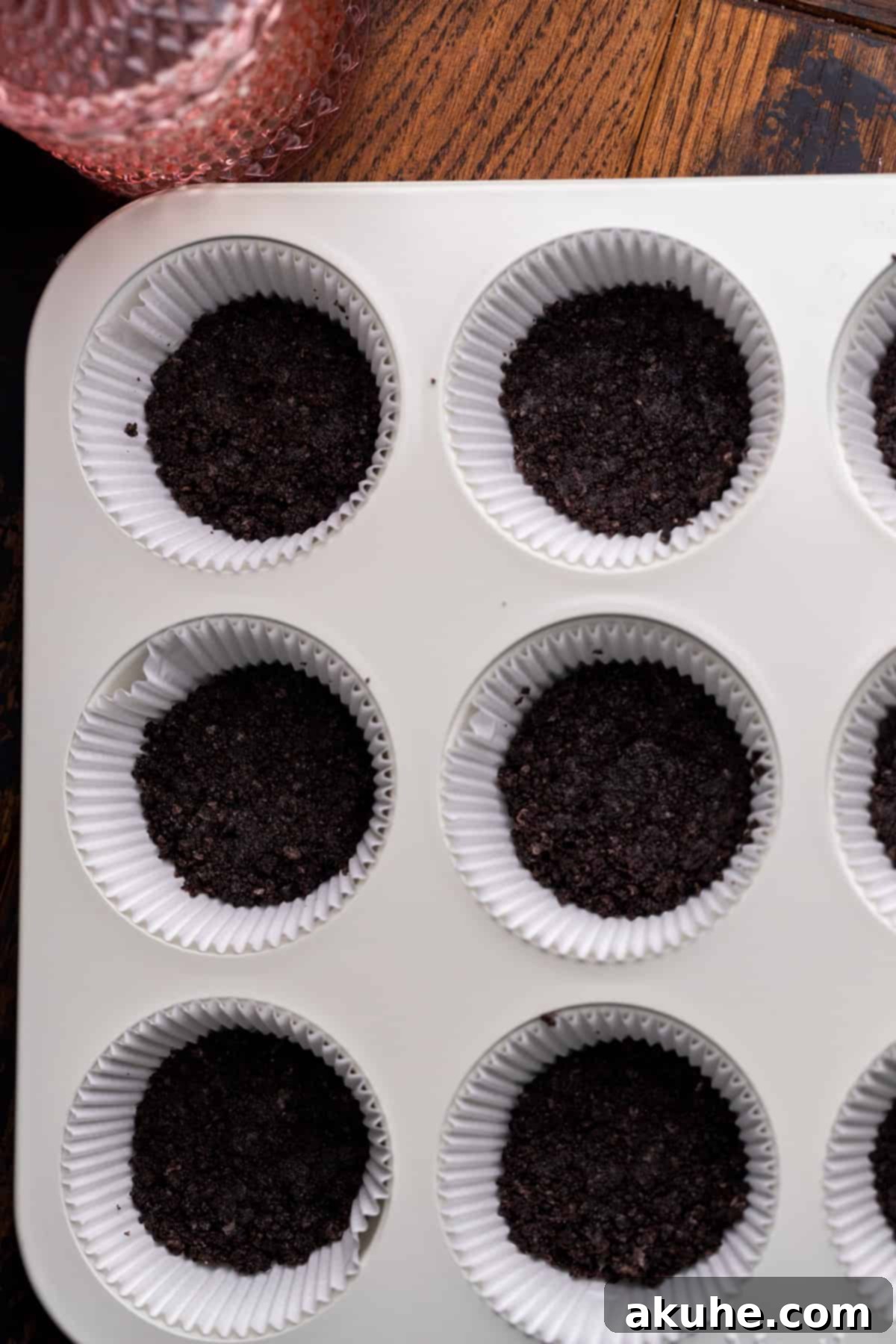 Bite-Sized Chocolate Cheesecakes 4 Crushed Oreo crust pressed into muffin liners, ready for baking.